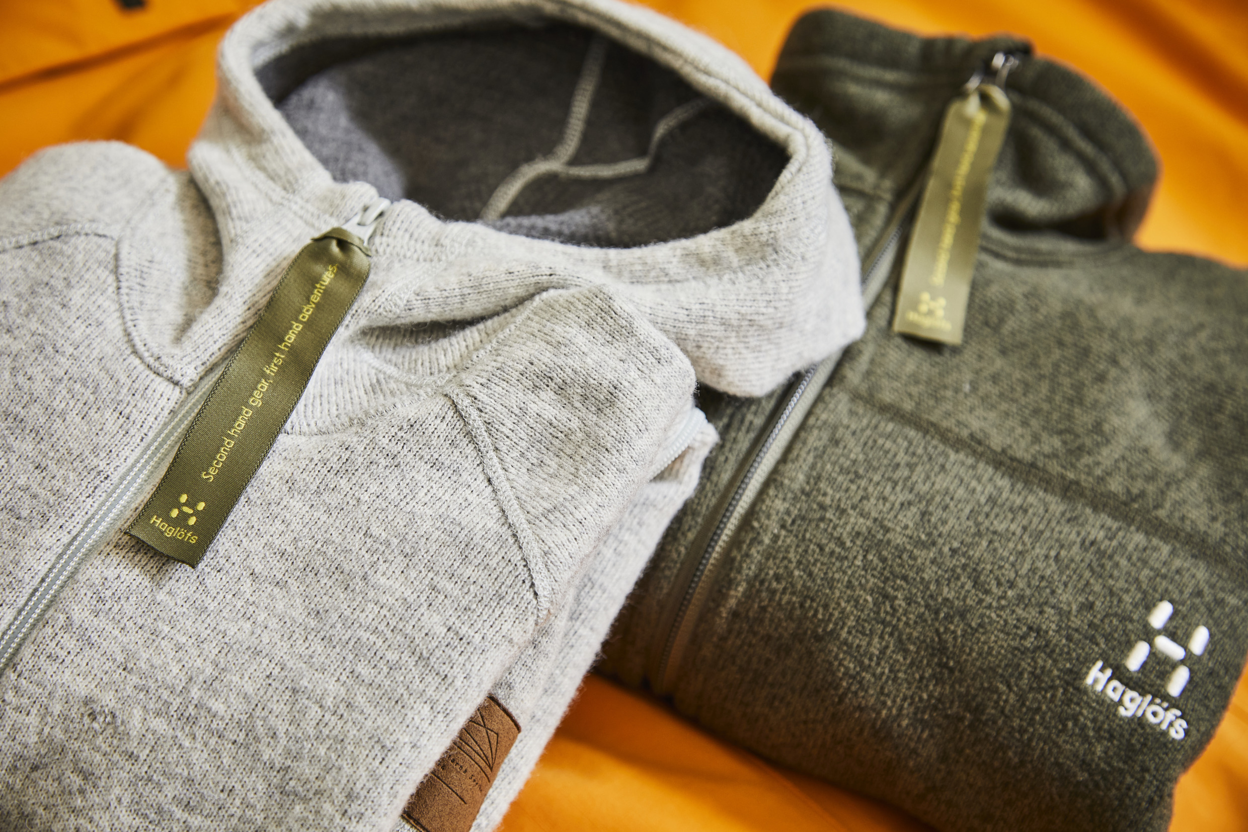 Zwei Pullover von Haglöfs liegen fein säuberlich gefaltet auf einem Tisch.