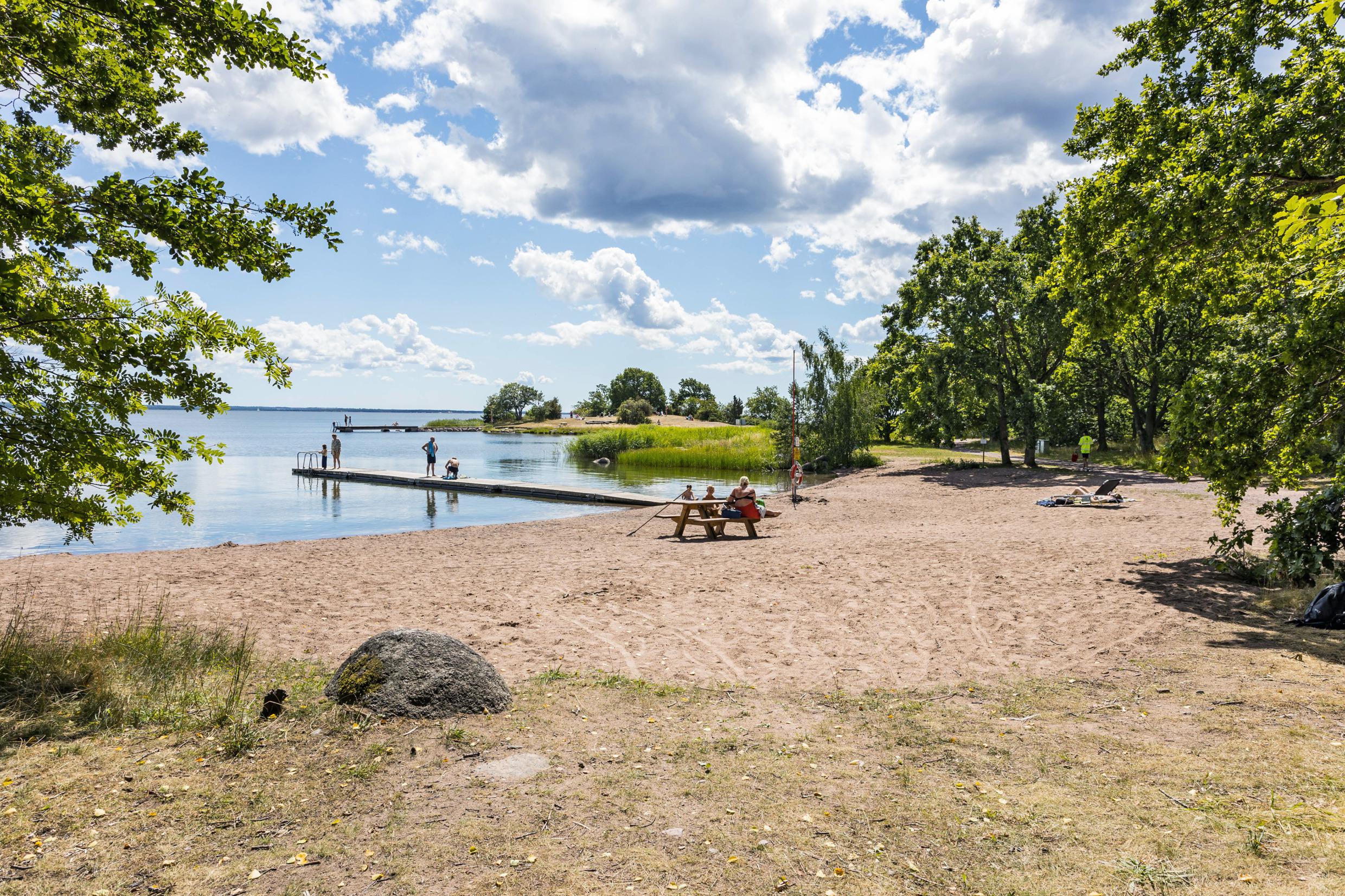 Mensen genieten van een zandstrand tijdens een zomerdag.