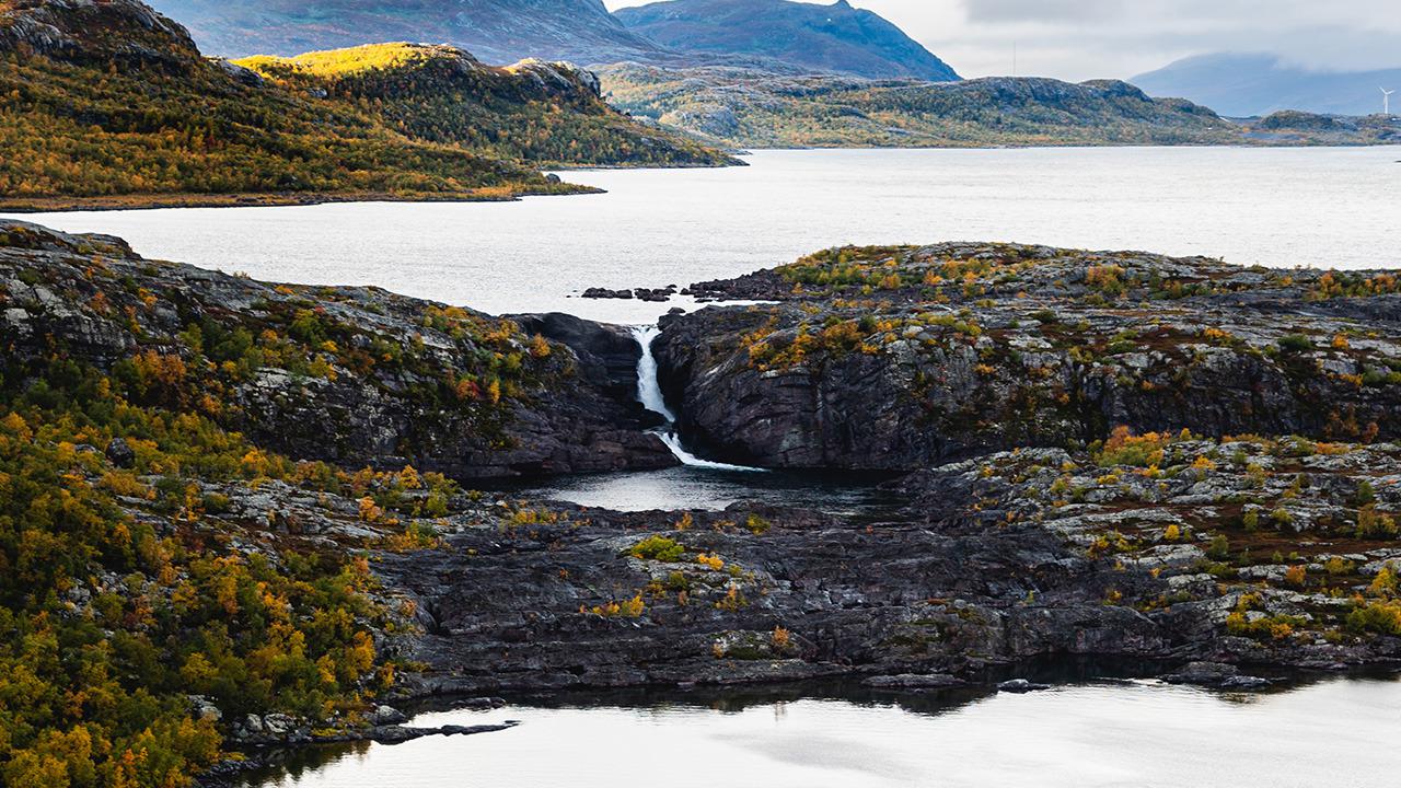 Ein riesiger See mit einem Wasserfall, der sich mit einem anderen See verbindet.