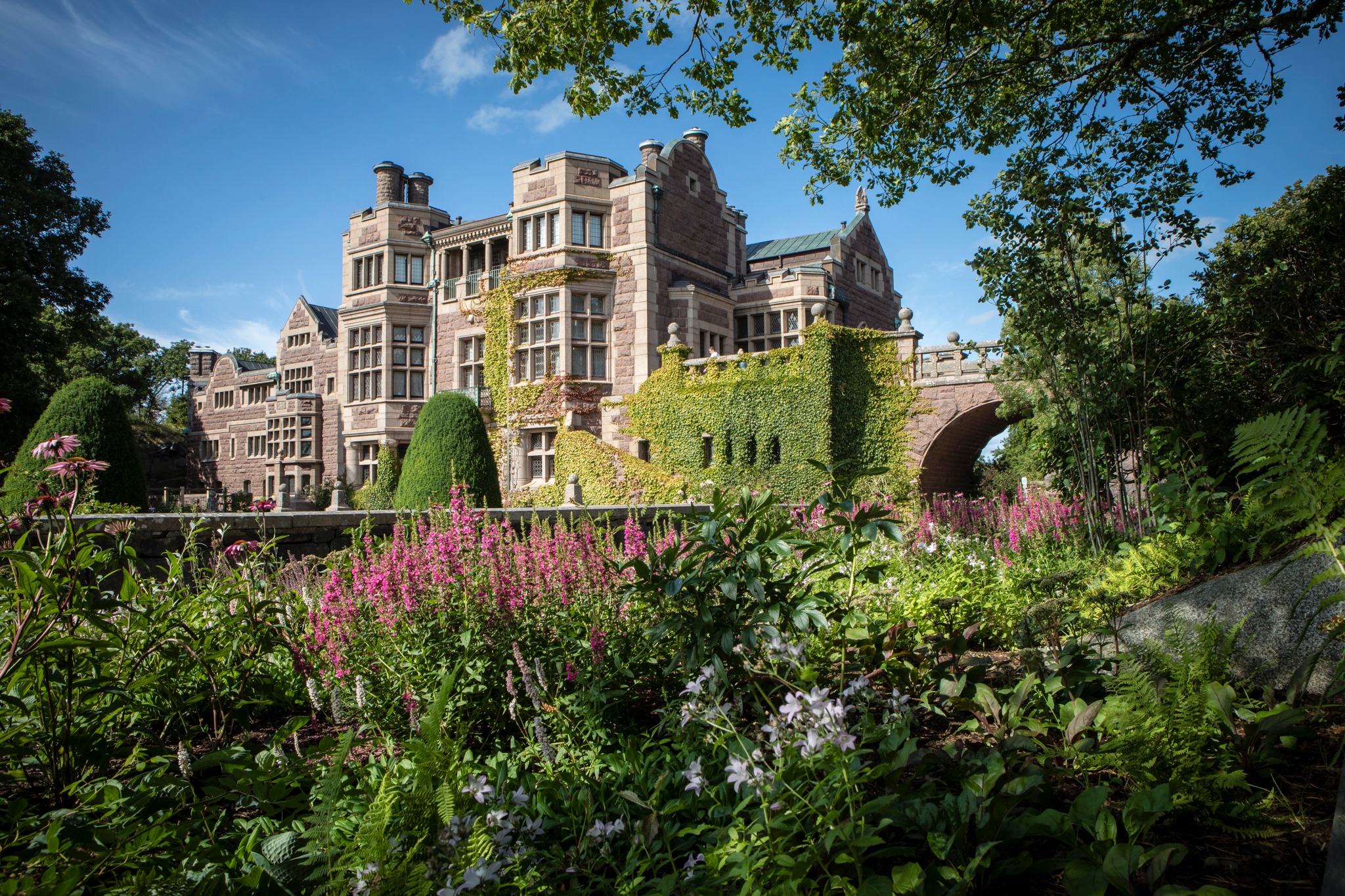 Tjolöholm Castle surrounded by greenery during summer.