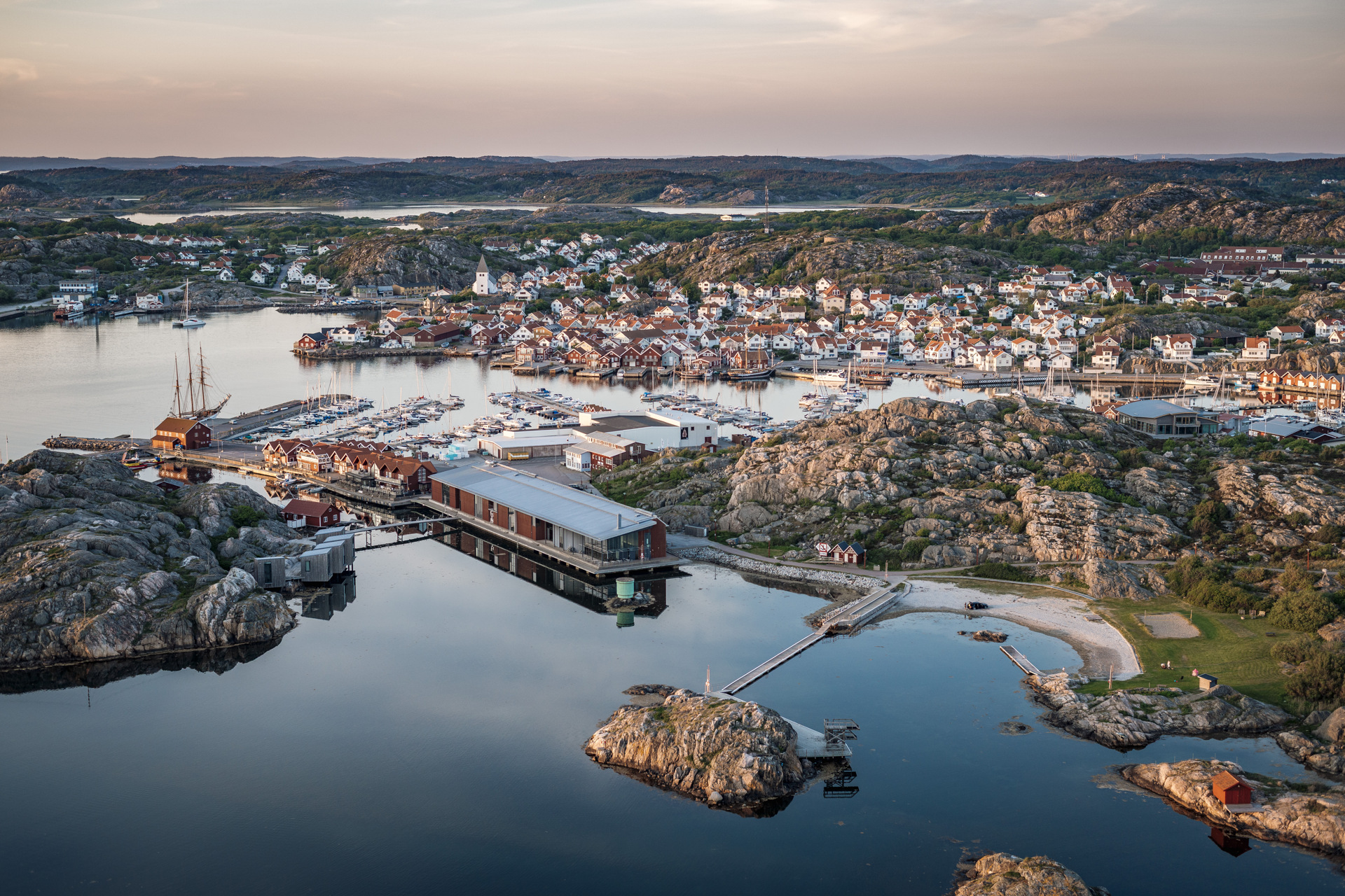 Aerial view of the Nordic Watercolour Museum by the sea, with Skärhamn and its rocky coastline in the background.