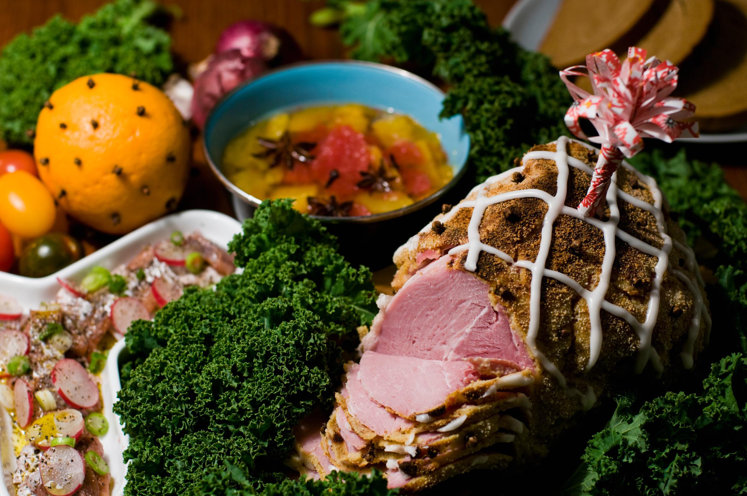 Der Weihnachtsschinken ist, umgeben von weiteren Speisen auf dem Tisch angerichtet.