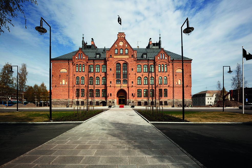 The historic brick façade of Elite Hotel Mimer in Umeå, a hotel housed in a former school building.
