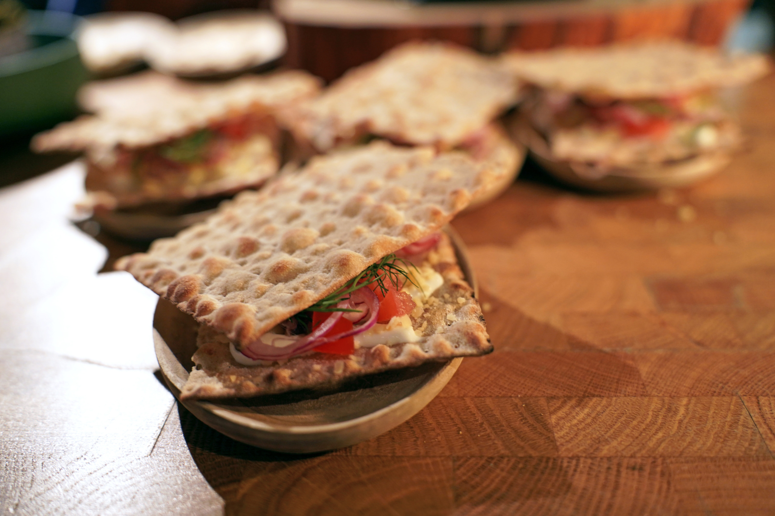 'Fermented herring, 'Surströmming' on a buttered flatbread with sliced egg, onion, tomatoes and dill.