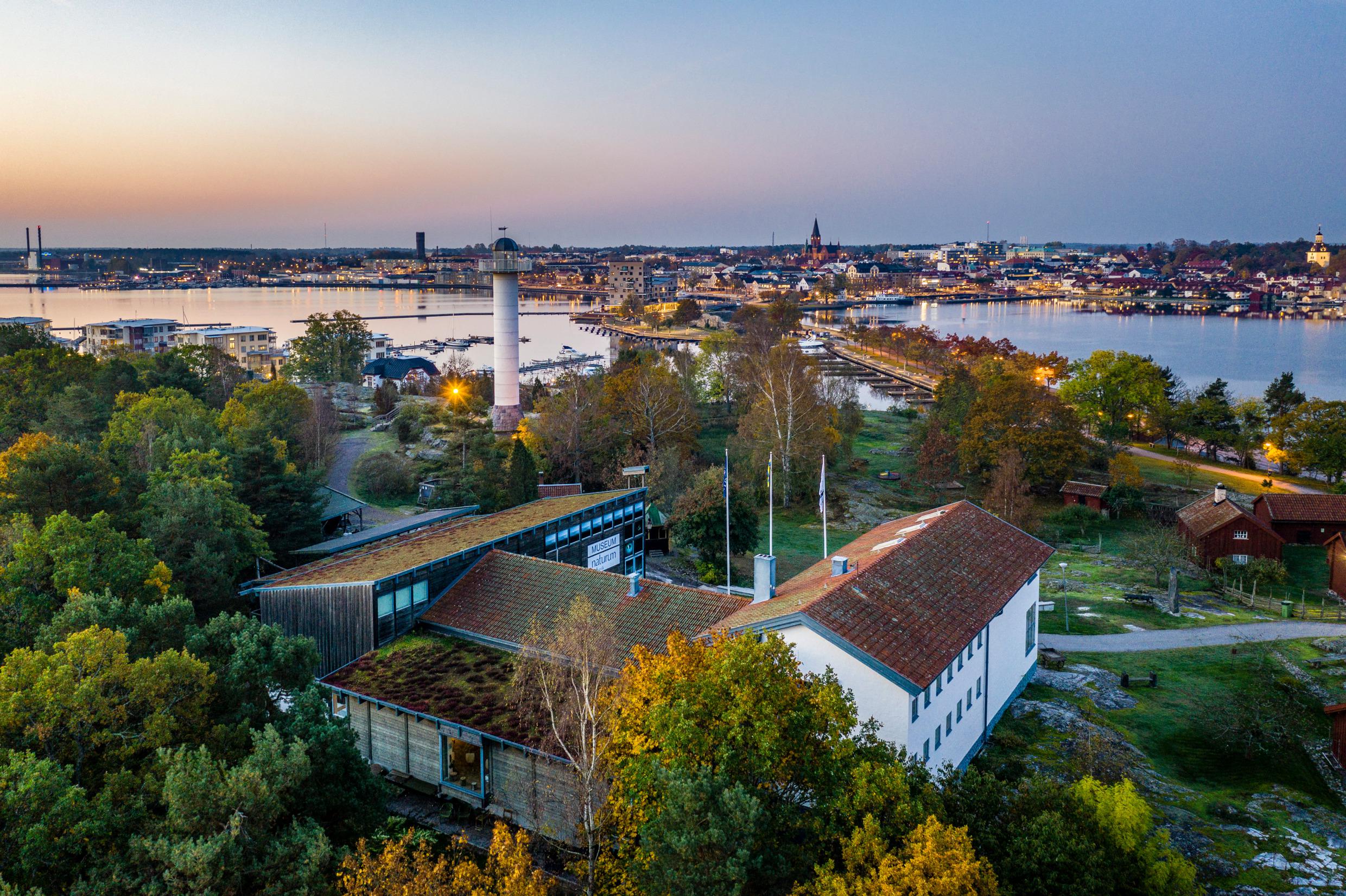 Luchtfoto van een stad aan het water bij zonsondergang.