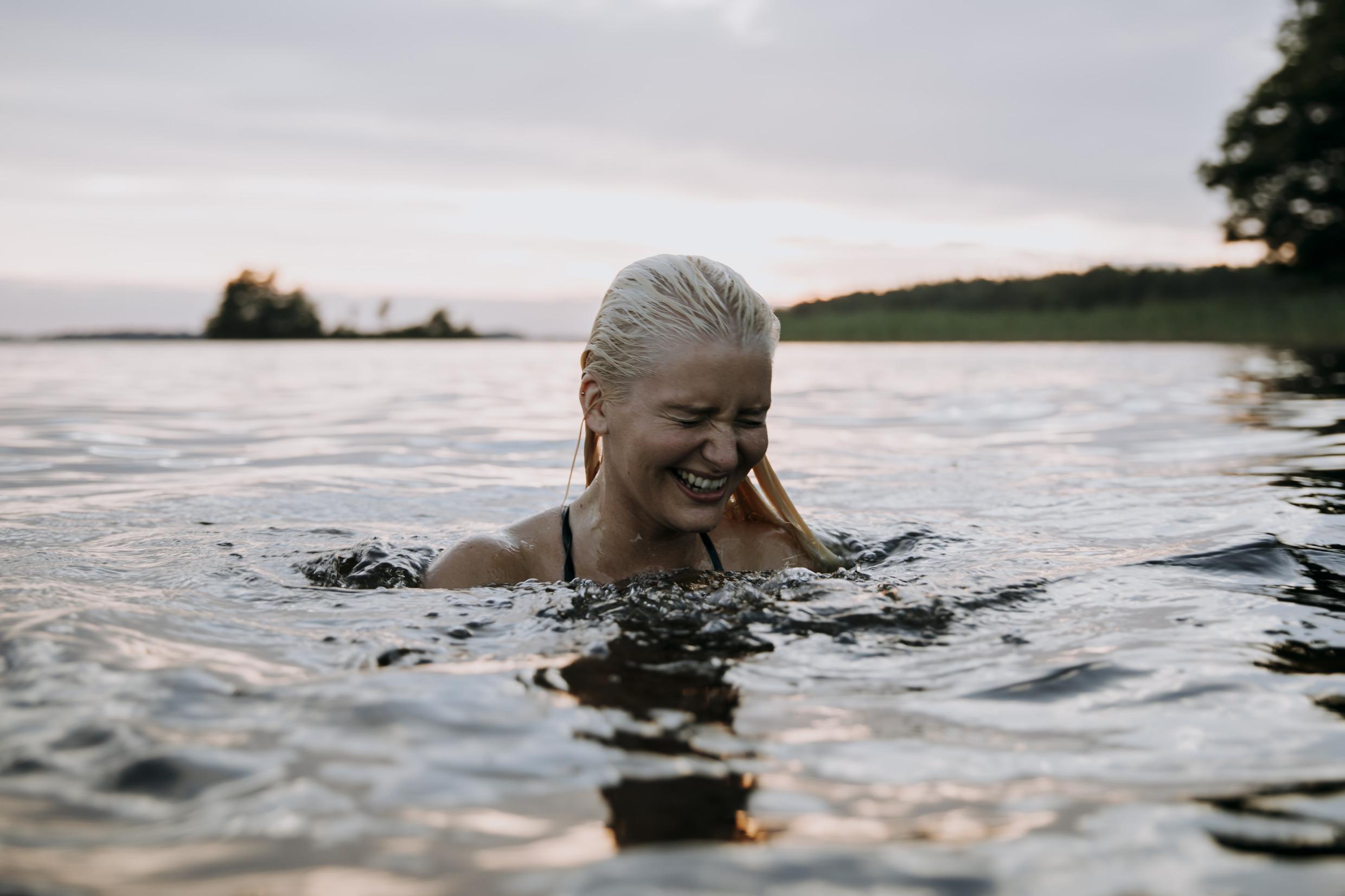 The head of a woman above the surface in a lake.