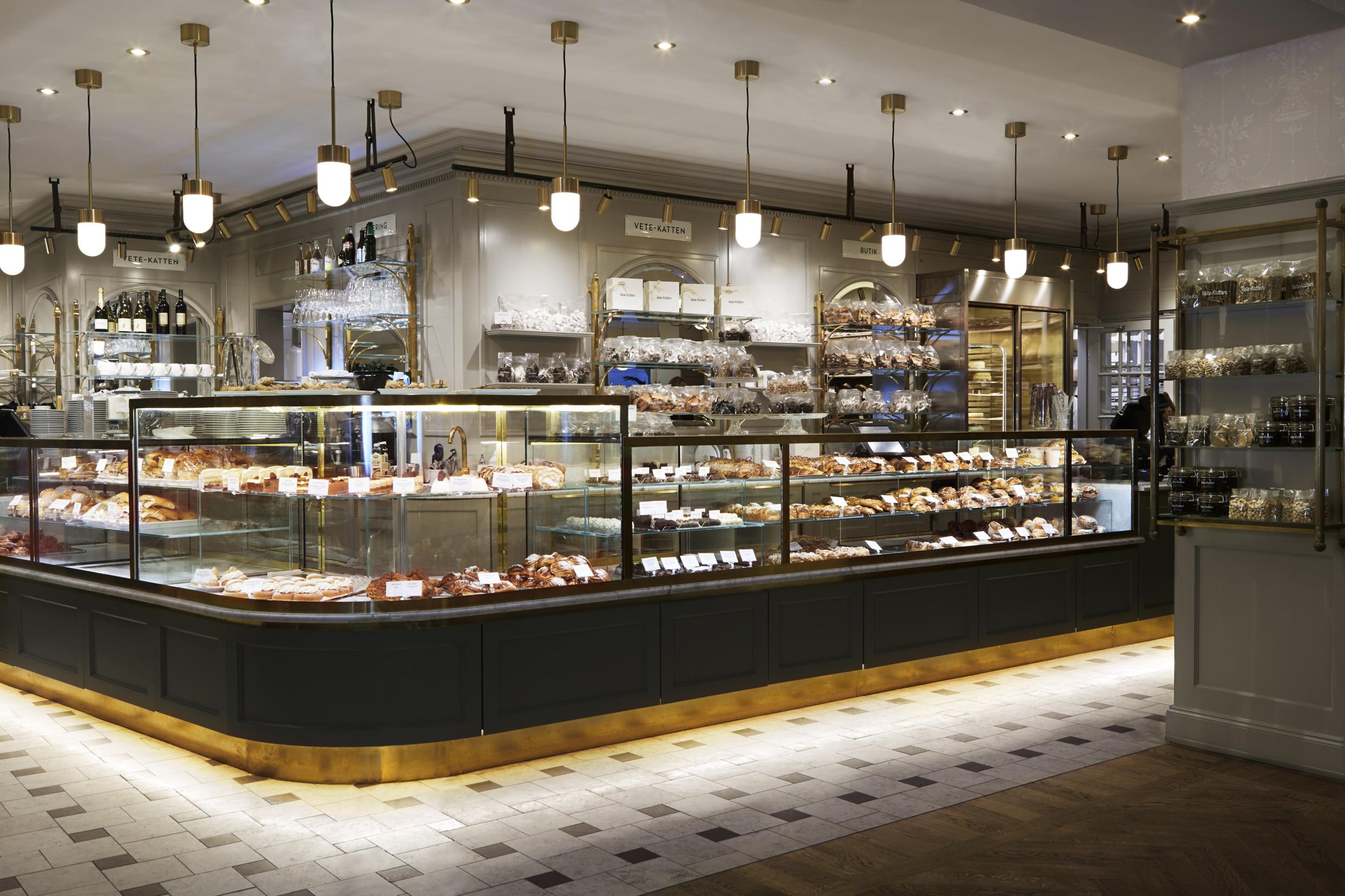 Un comptoir en verre chez Vete-katten avec de nombreuses pâtisseries et brioches.