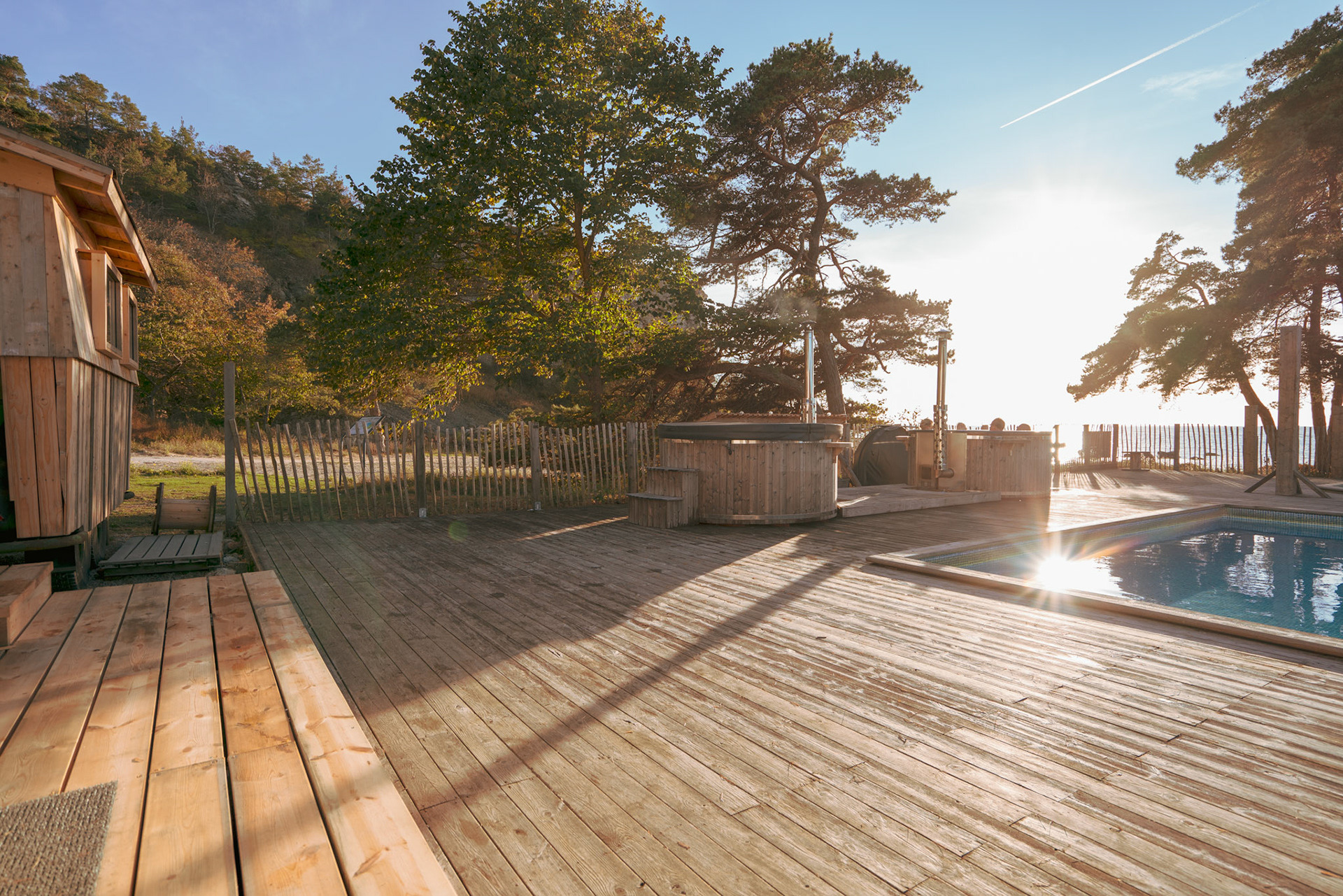 Wooden deck with sauna, hot tubs and a pool at Vidhave’s outdoor spa by the beach, north of Visby.