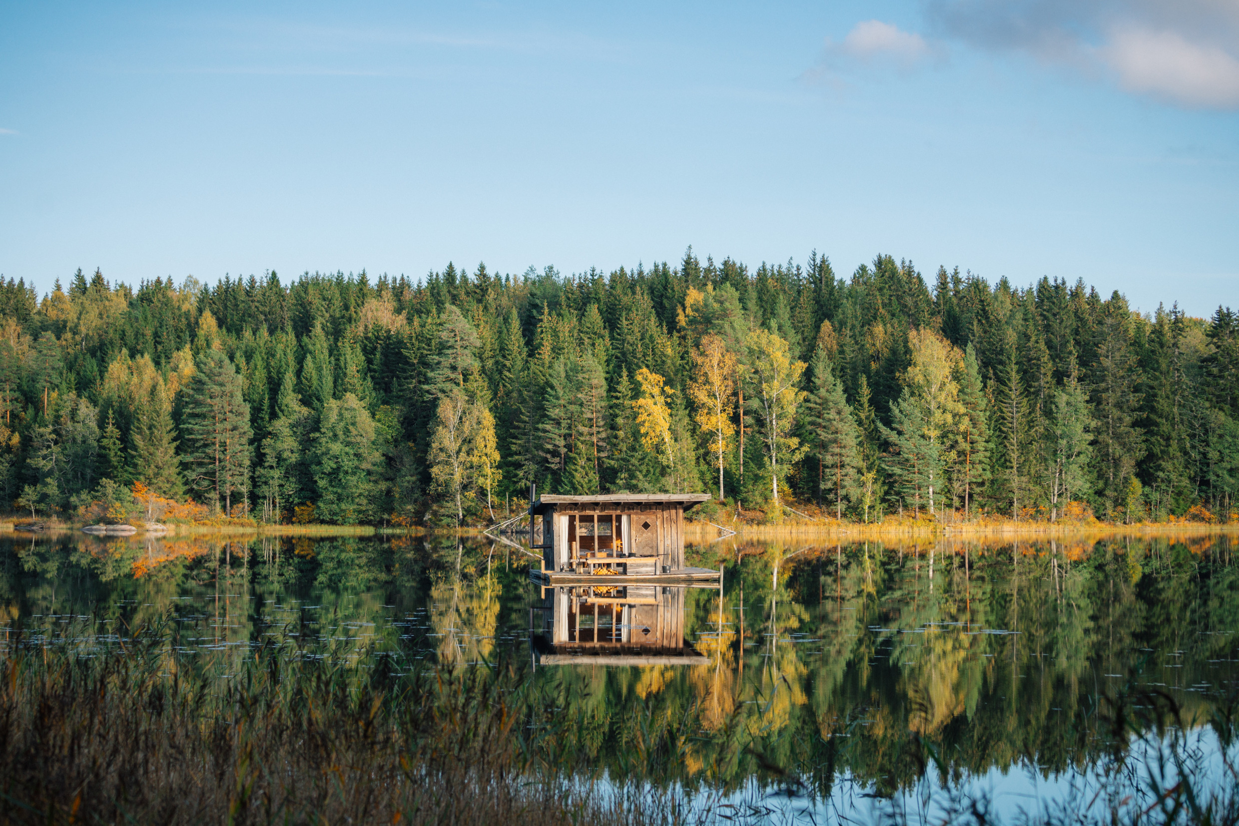 Ein Hotelzimmer mit großen Glasfenstern auf einem Floß auf einem See.