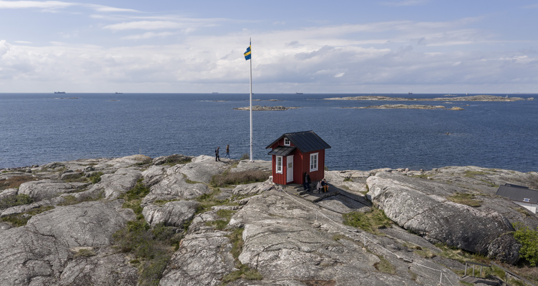 A small red pilot’s lookout tower on the rocky coast of Vrångö, overlooking the sea and surrounding islands.