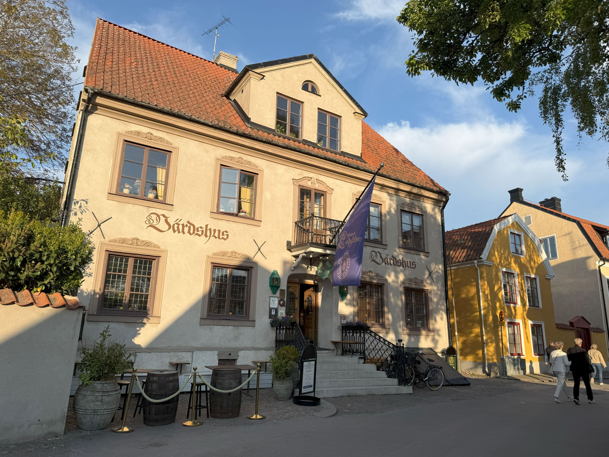 Sunlit façade of Värdshuset Lindgården in Visby, a historic inn serving Swedish cuisine.