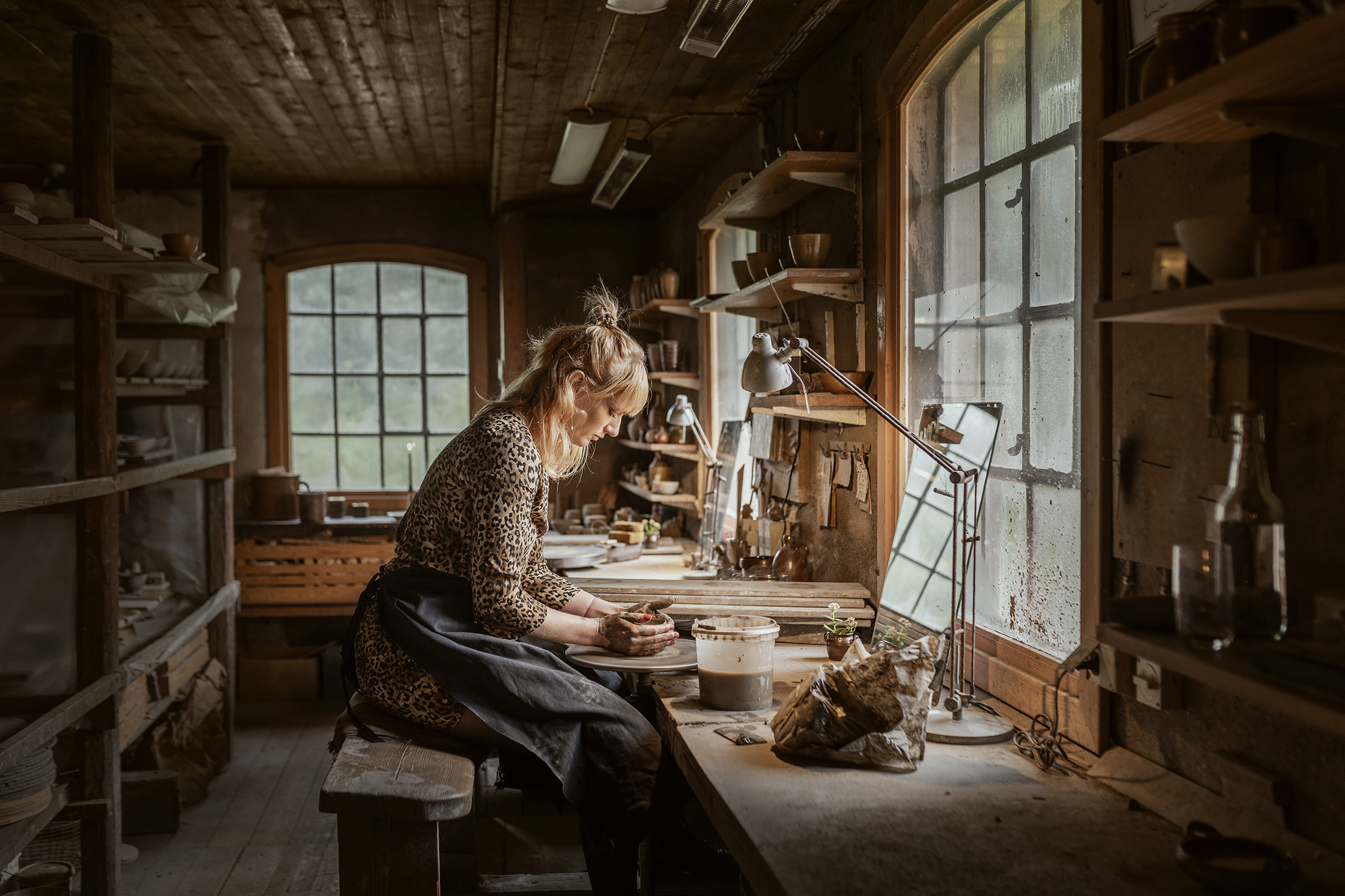 A person works with clay in a pottery workshop at Wallåkra Stoneware Factory in Skåne.