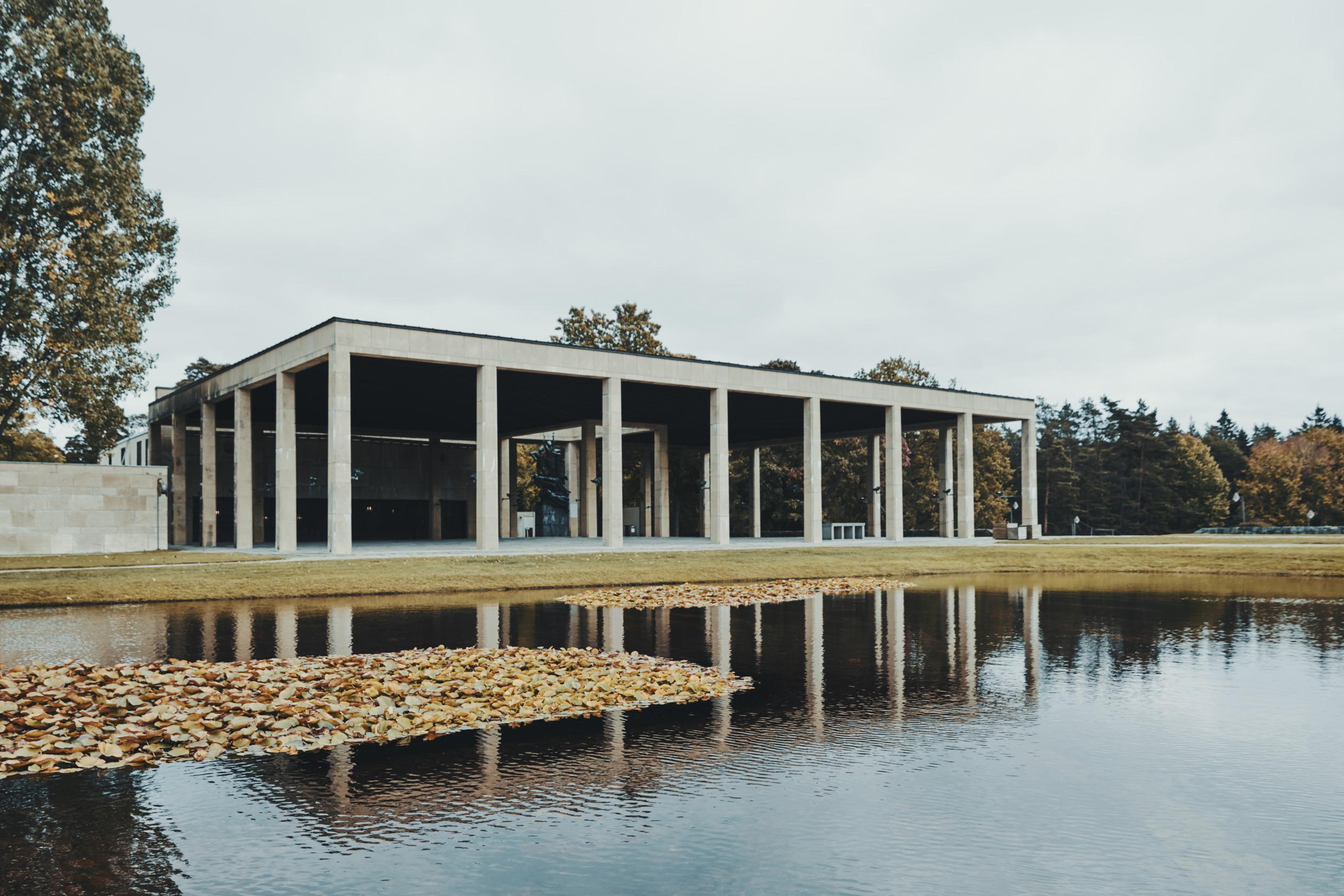 A building and a pond at Skogskyrkogården cemetery in Stockholm.