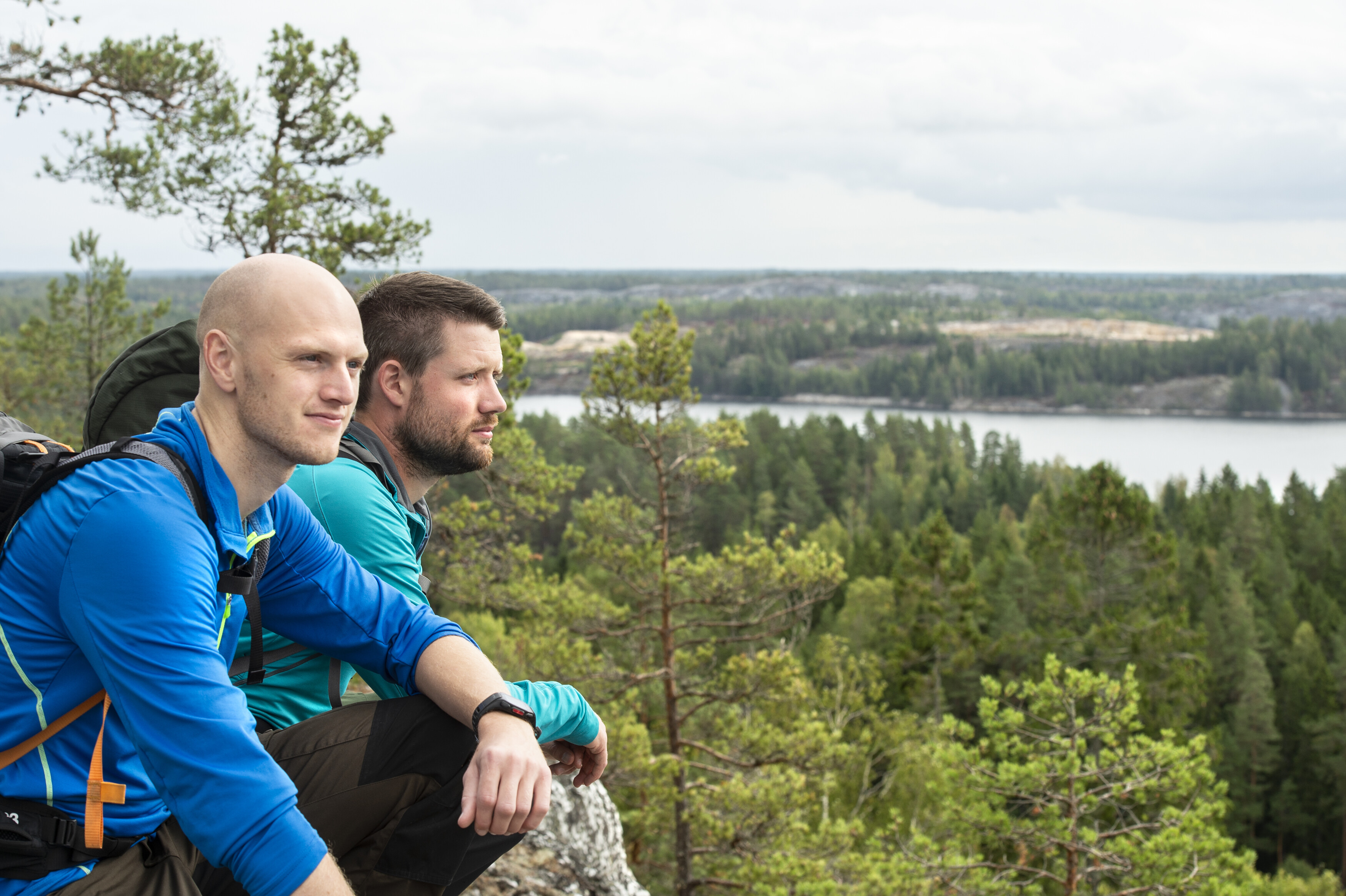 Two hikers in nature looking out from a view point.