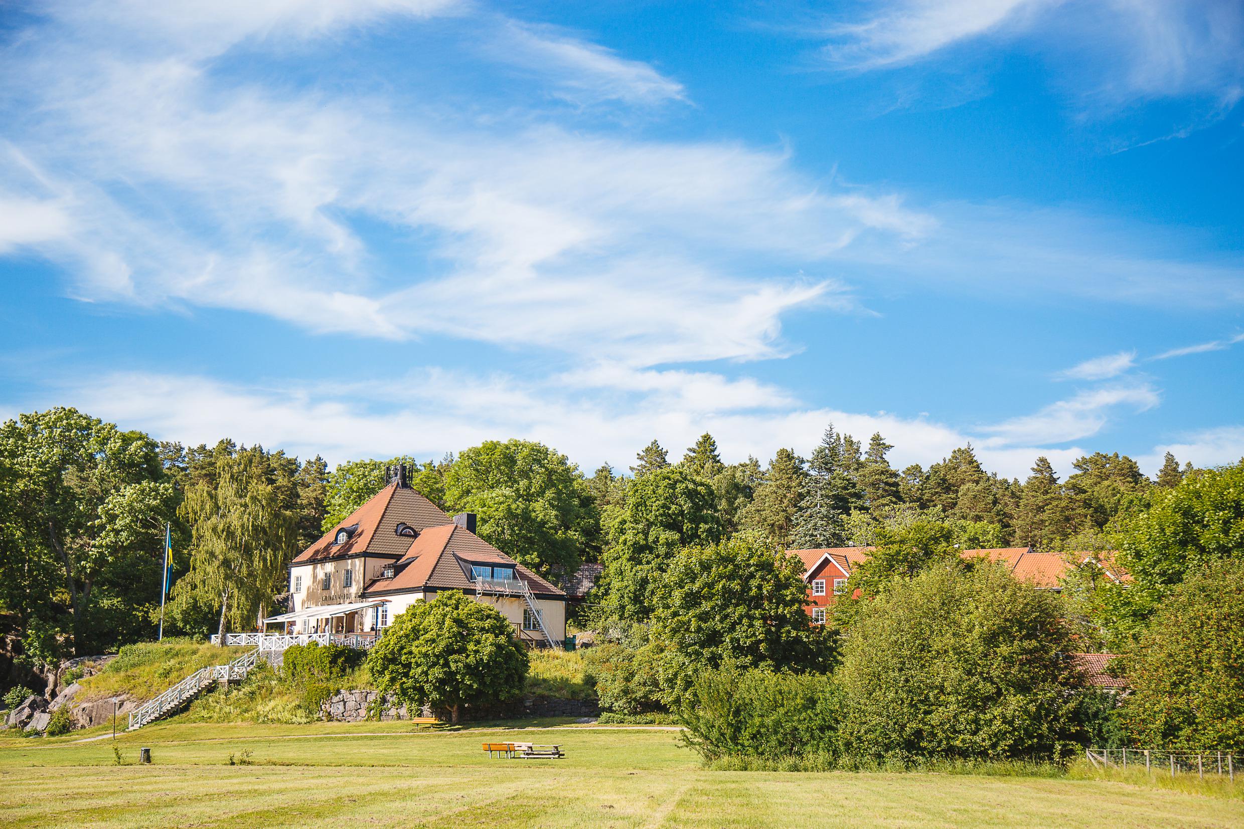 Het huis Grinda Wärdshus omgeven door groen.