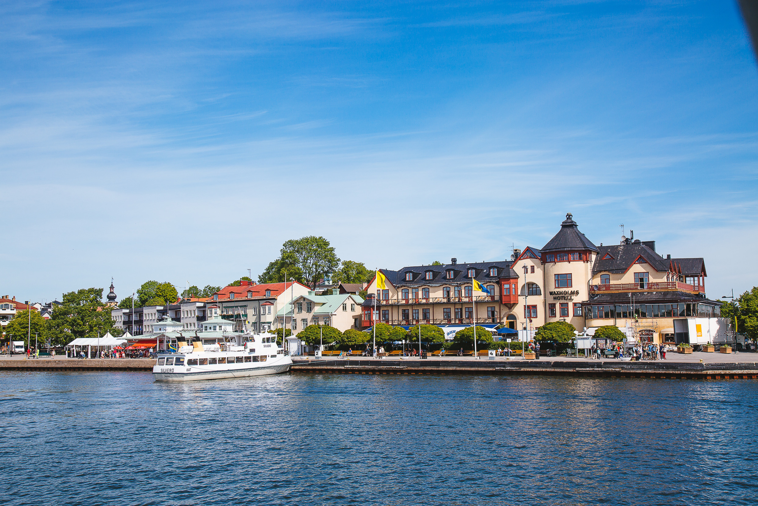 Ein Boot legt am Ufer einer kleinen Inselstadt an.