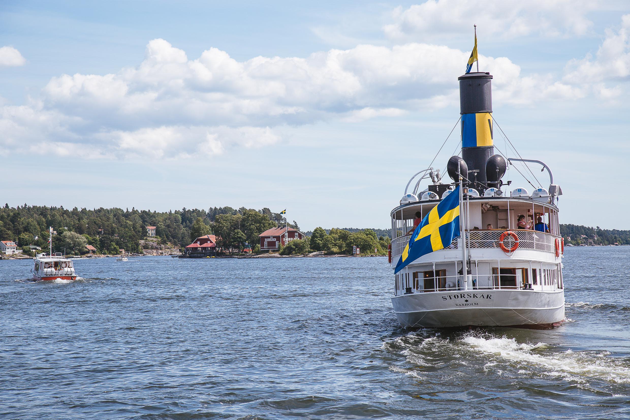 Een stoomboot met Zweedse vlag op weg van de stad Stockholm naar de archipel.