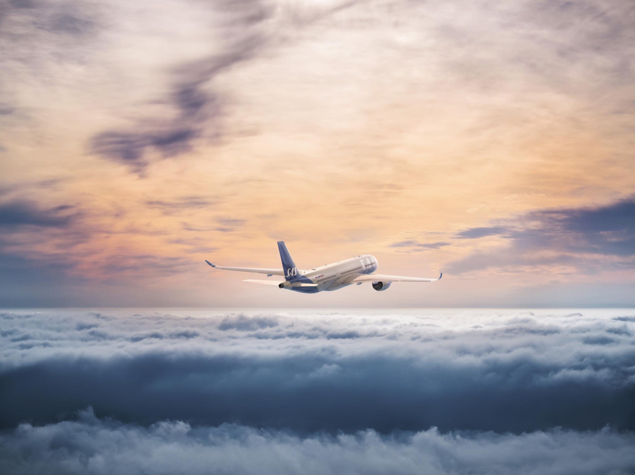 An airplane flies above the clouds.