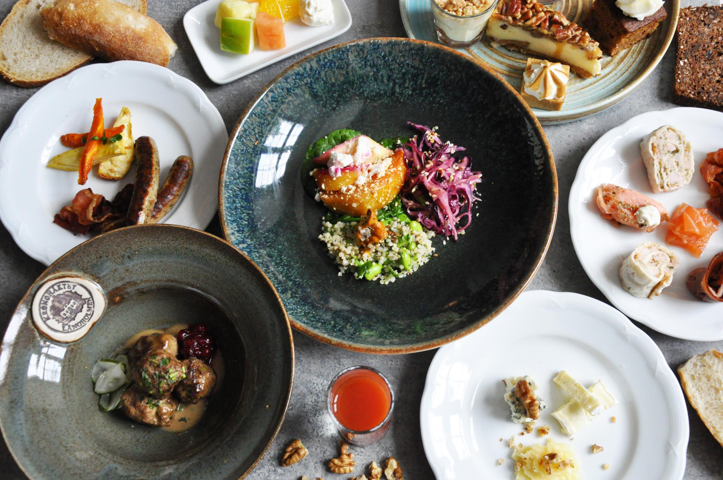Different plates with food on a grey table.