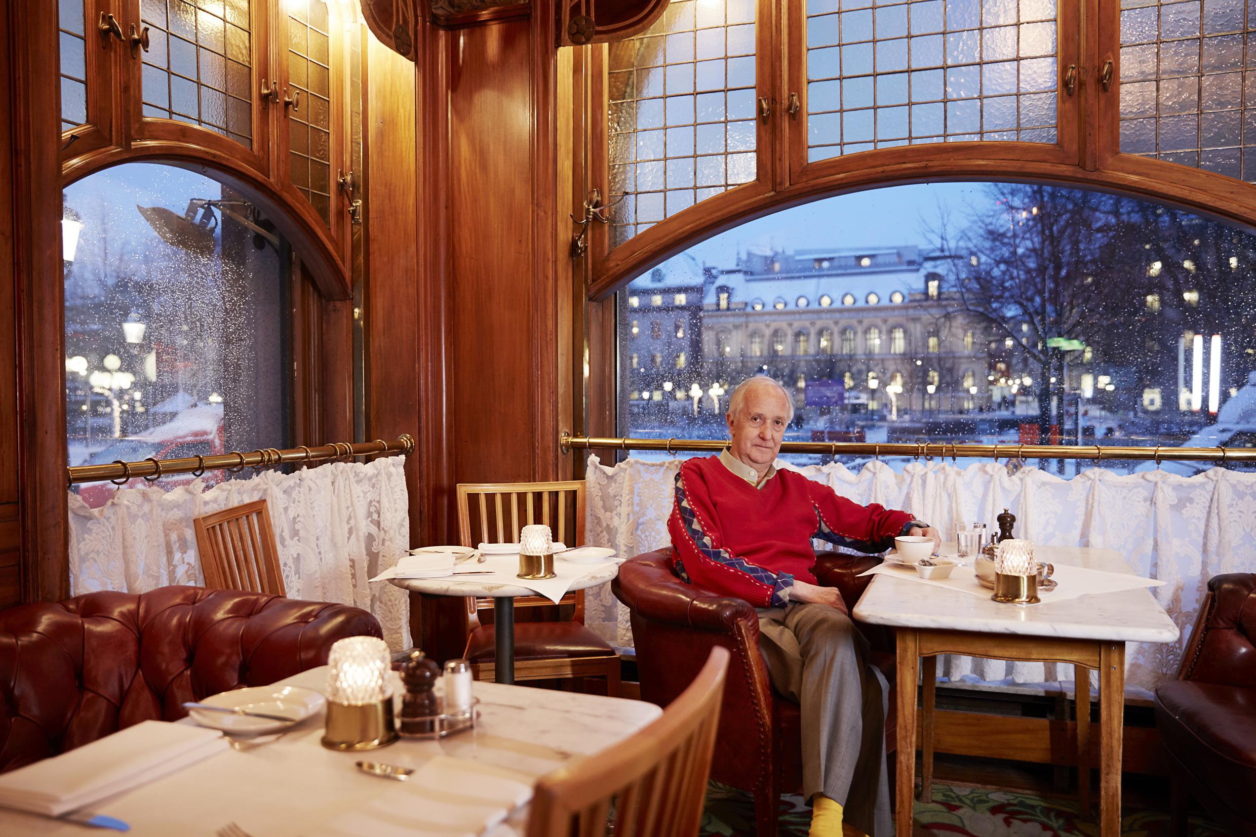 Gallery founder Björn Wetterling sits at a window table at Operabaren in Stockholm with a cup of coffee. It's winter weather outside.