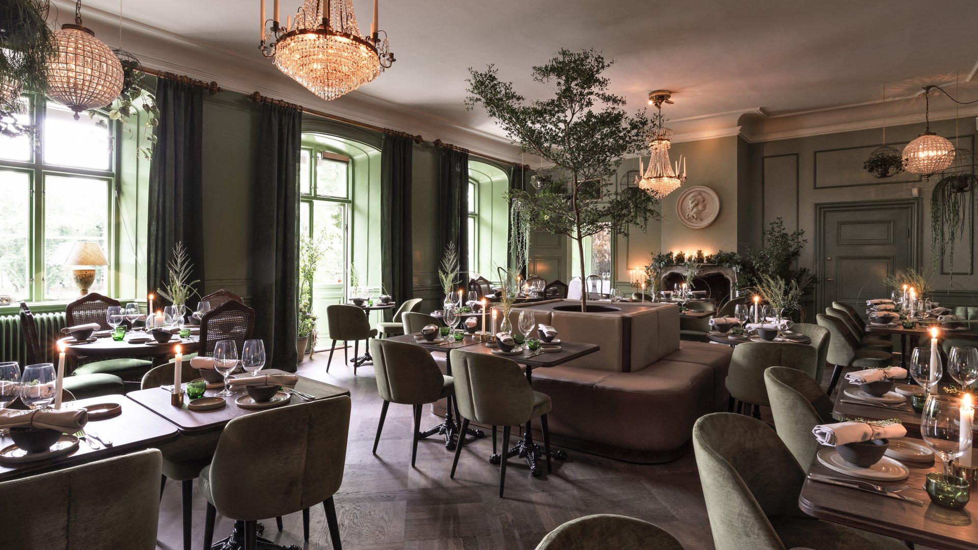 Le restaurant Råkoko, situé au château d'Åkeshof, se distingue par ses tables magnifiquement dressées, son décor verdoyant, ses lustres et son ambiance chaleureuse à la lueur des bougies.