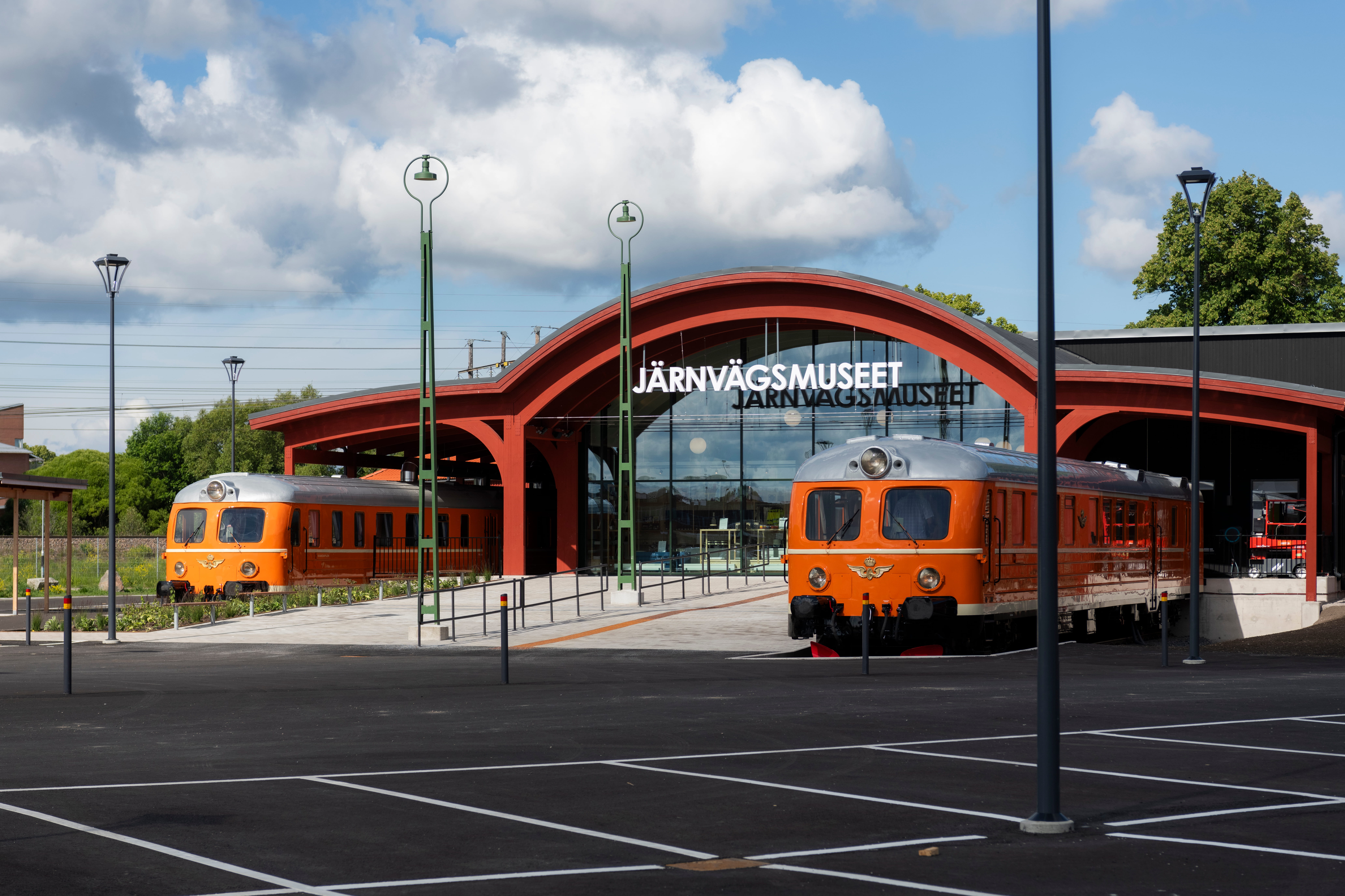 Entrance of Järnvägsmuseet in Gävle, featuring two orange trains framing the entrance.