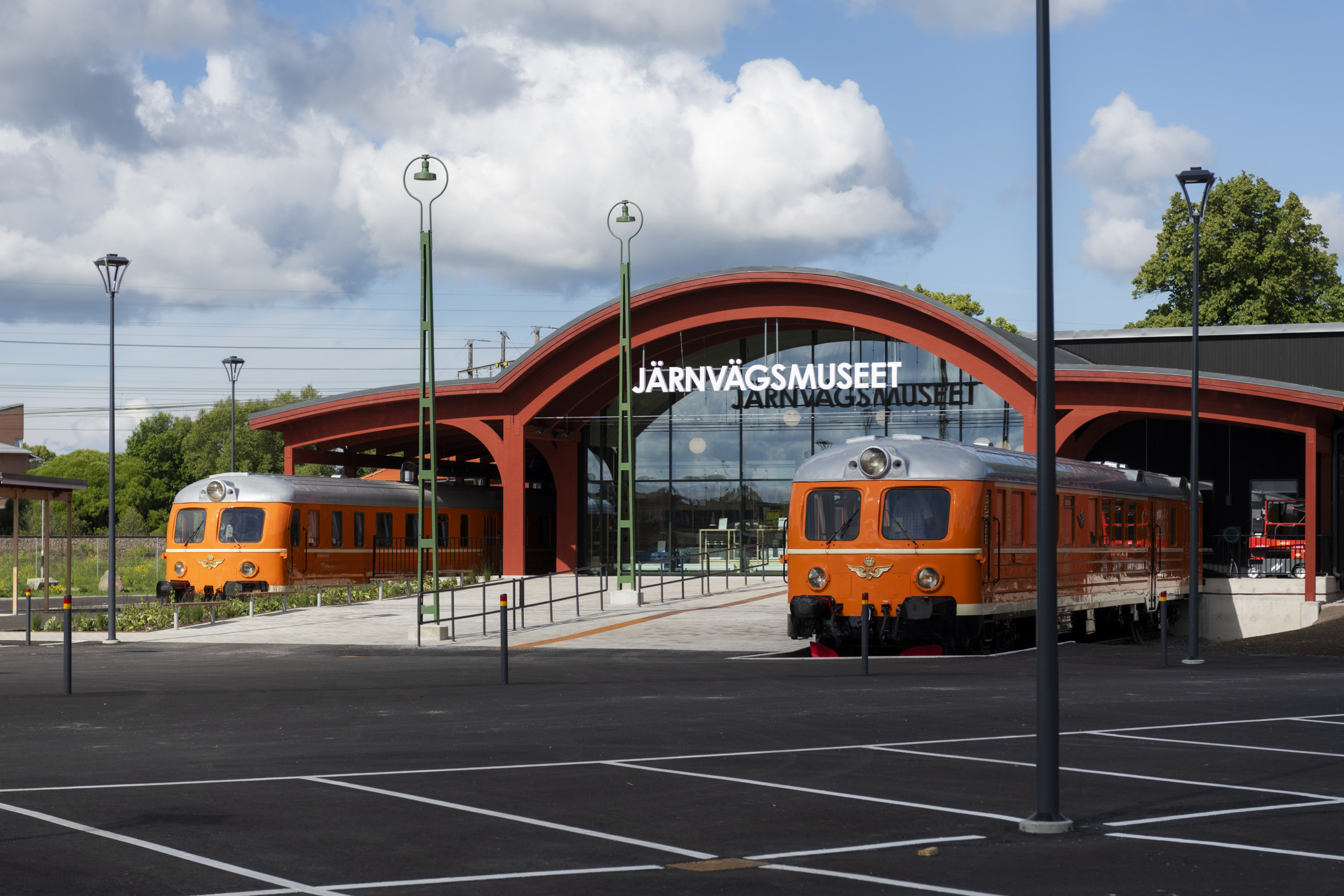 Ingang van het Spoorwegmuseum in Gävle, met twee oranje treinen bij de ingang.