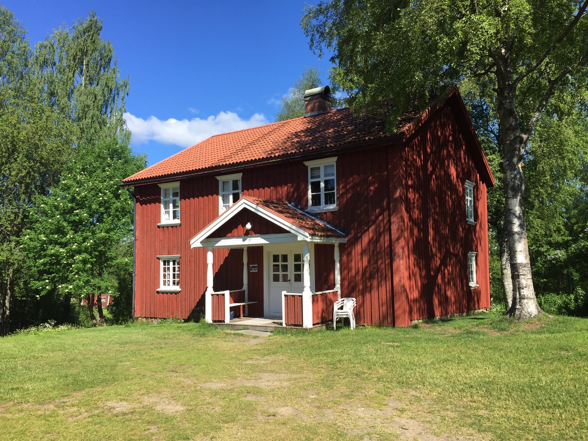 Rood houten huis in Värmland, omringd door bomen, waarvan gezegd wordt dat het een van de meest spookachtige plekken van Zweden is.