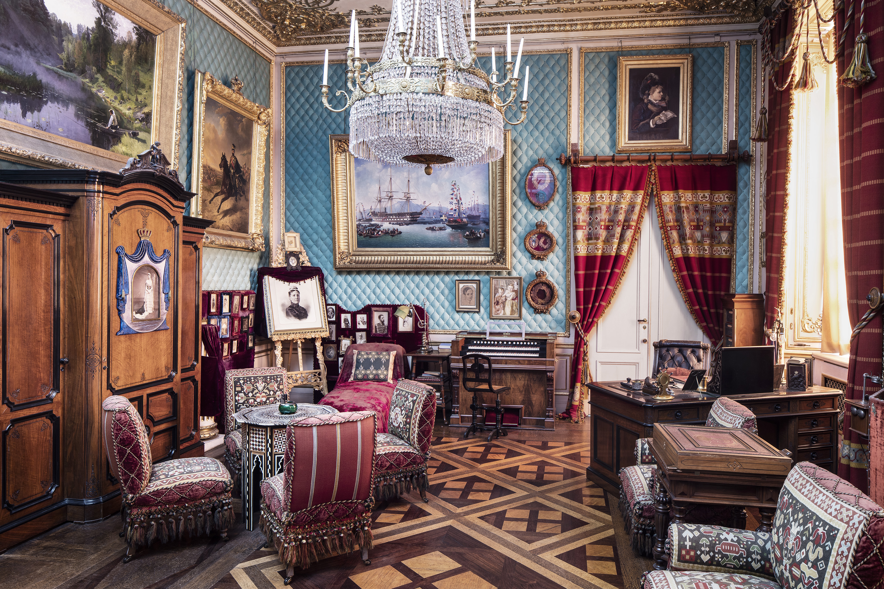 Oskar II’s Writing Room at the palace, featuring 19th-century furnishings, heavy drapes, ornate details, and early electric lighting.