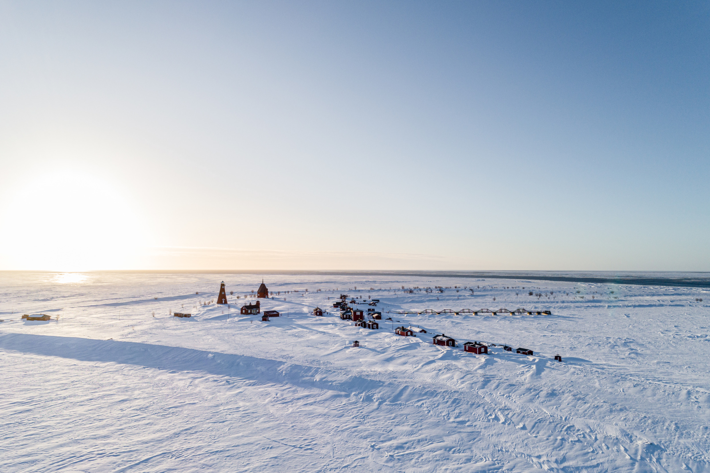 Het eiland Malören bedekt met sneeuw op een zonnige winterdag.