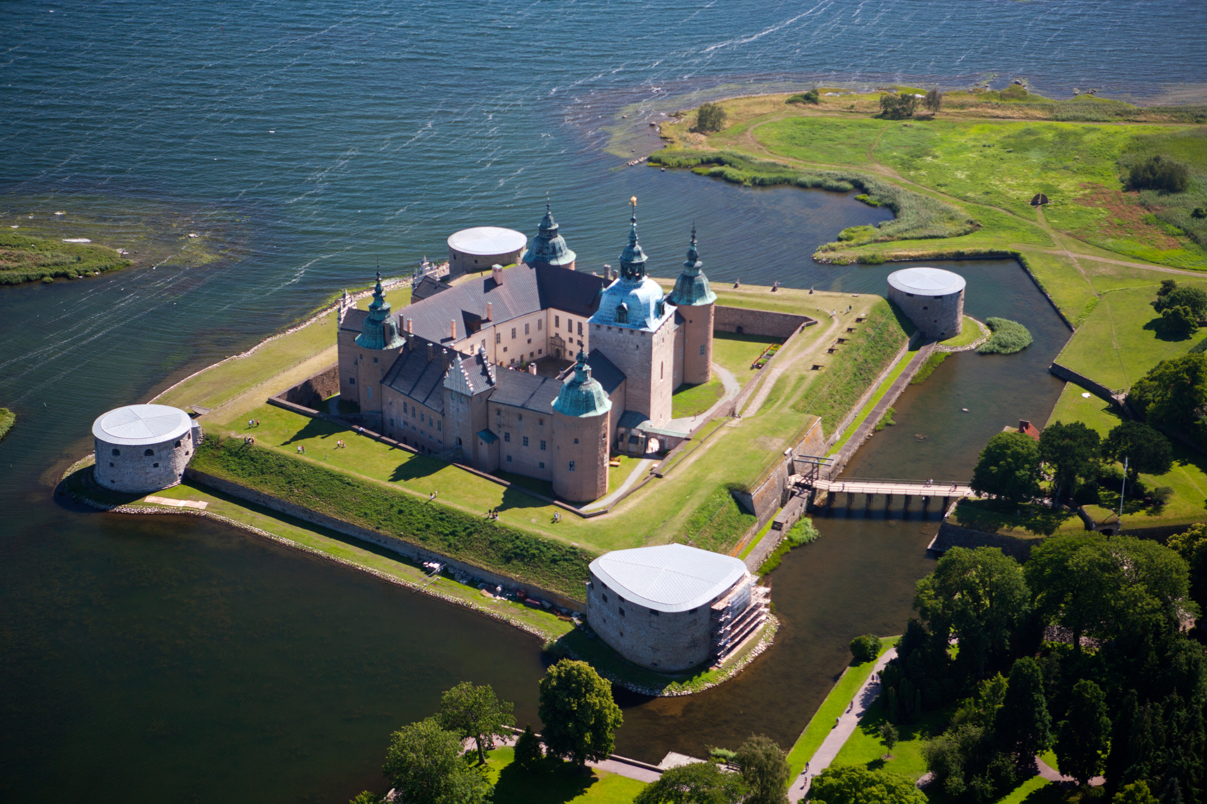 Luchtfoto van het kasteel van Kalmar, gelegen op een klein eiland omgeven door water en met een kleine brug naar het vasteland.