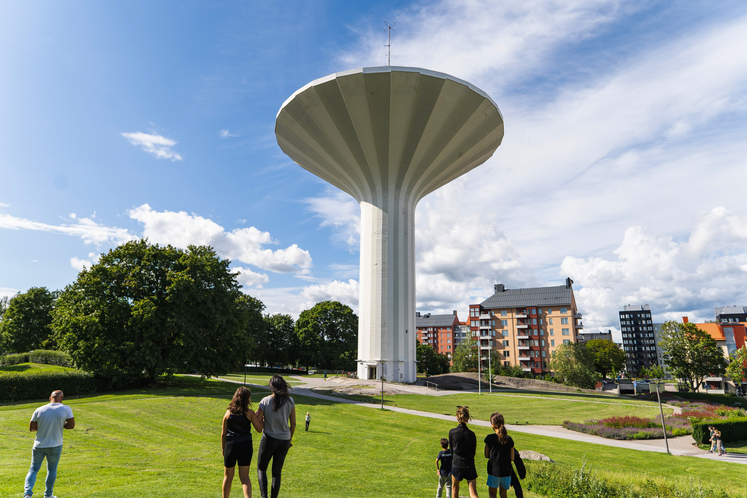 Mensen kijken omhoog naar een watertoren die eruitziet als een paddenstoel in Örebro.