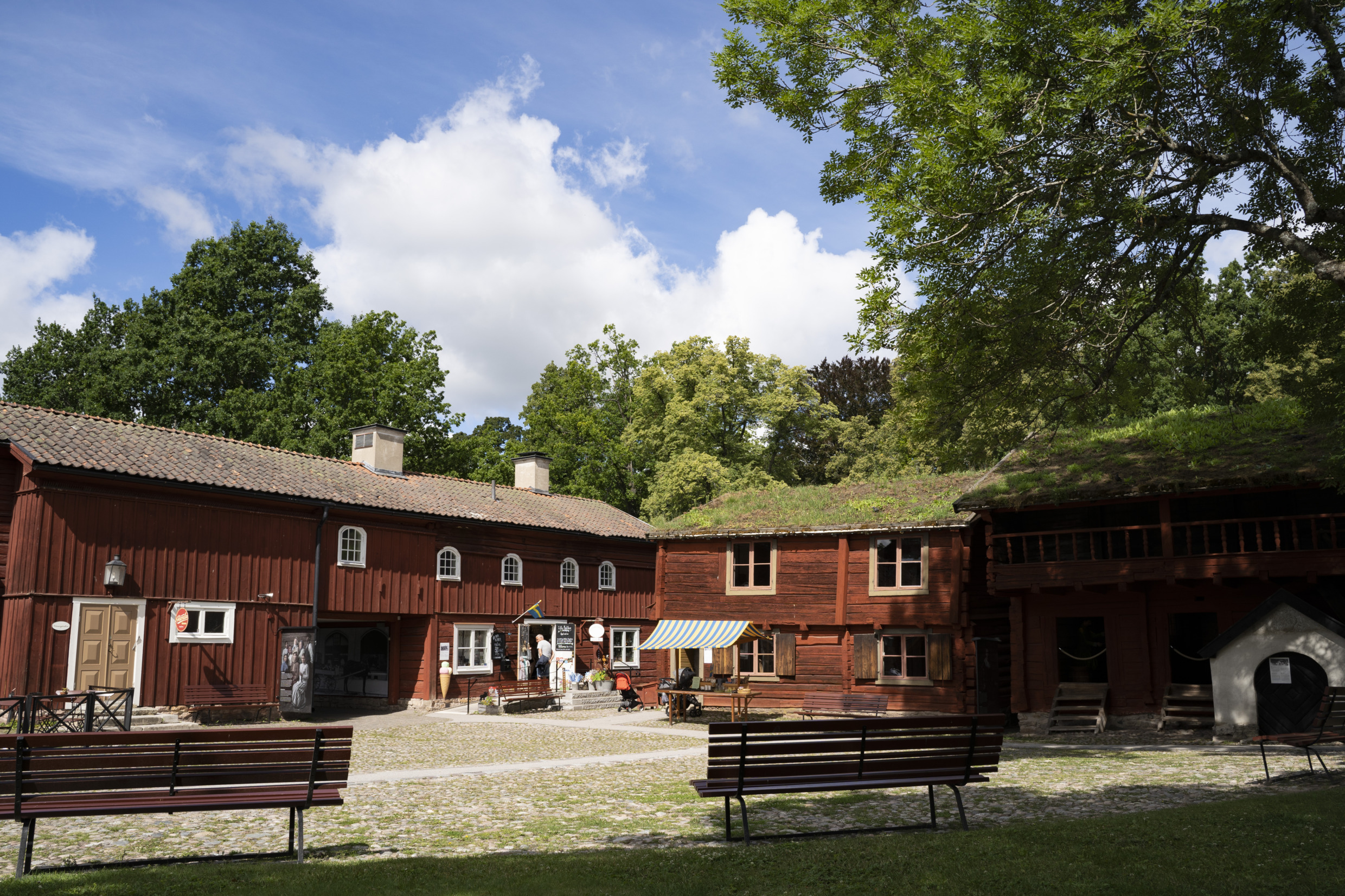 Maisons rouges en bois entourées d'arbres verts.