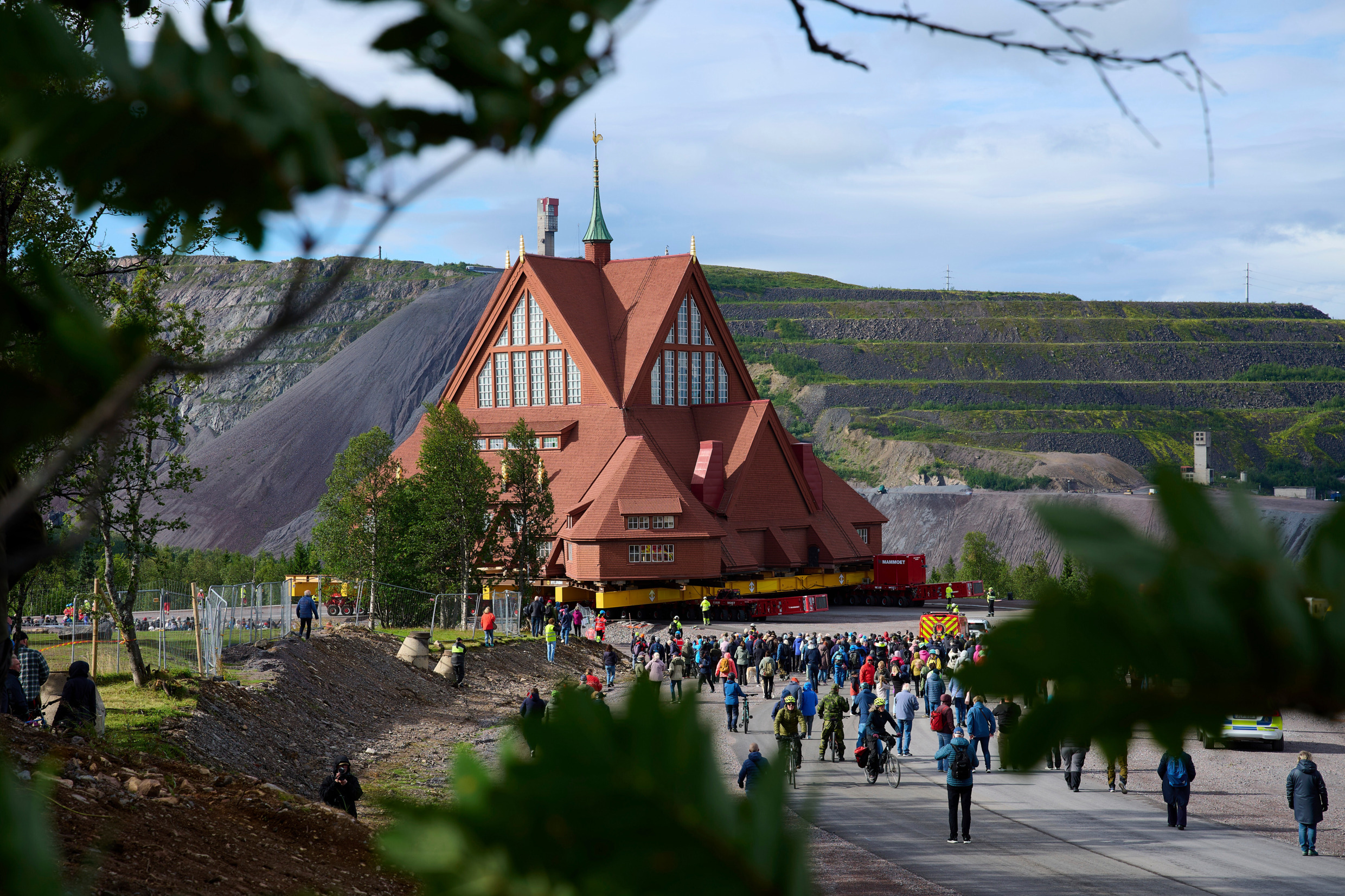 Met een mijn op de achtergrond wordt een grote kerk door de straat gereden.