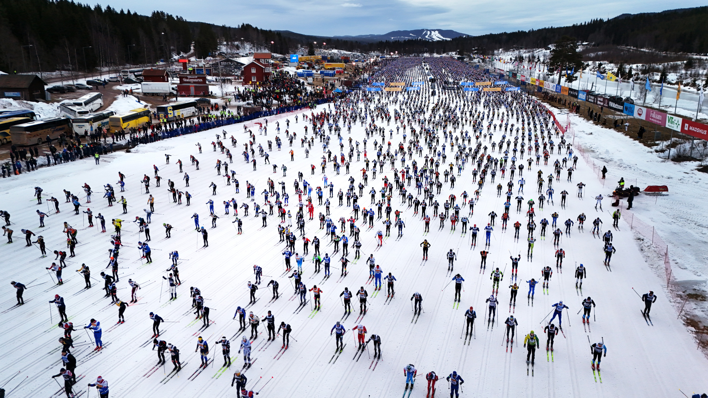 Vue aérienne de gens qui dévalent les pistes à ski en pleine nature.