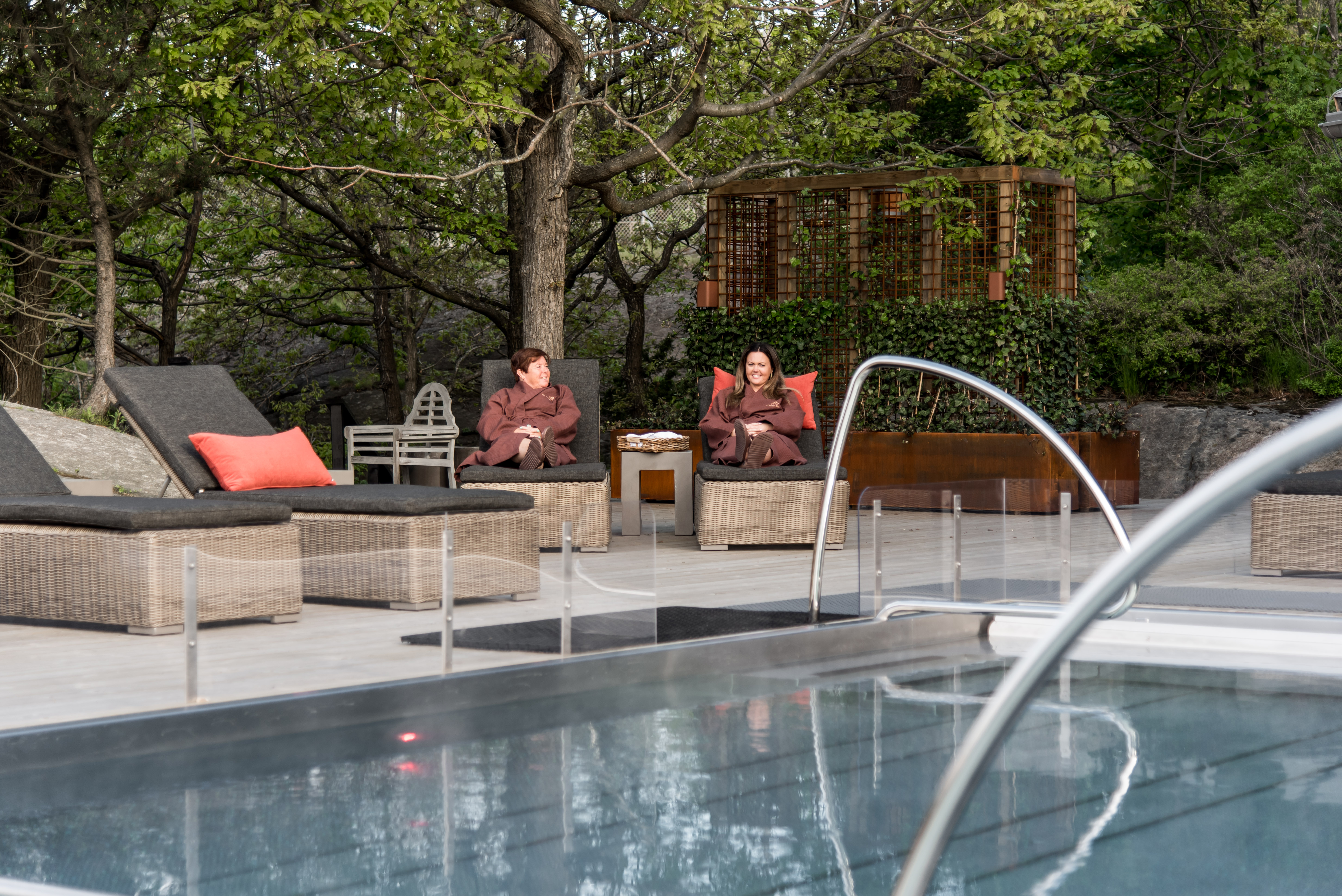 Two people on day beds near the pool.