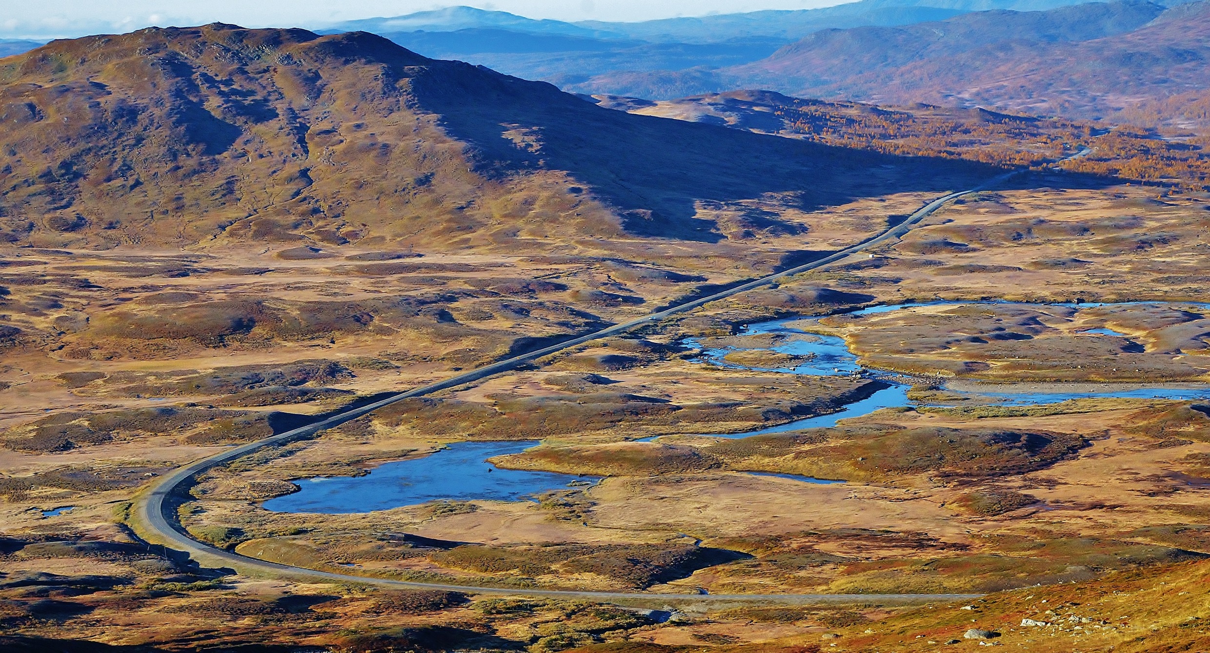 Een weg slingert door een bergplateau in het noorden van Zweden.