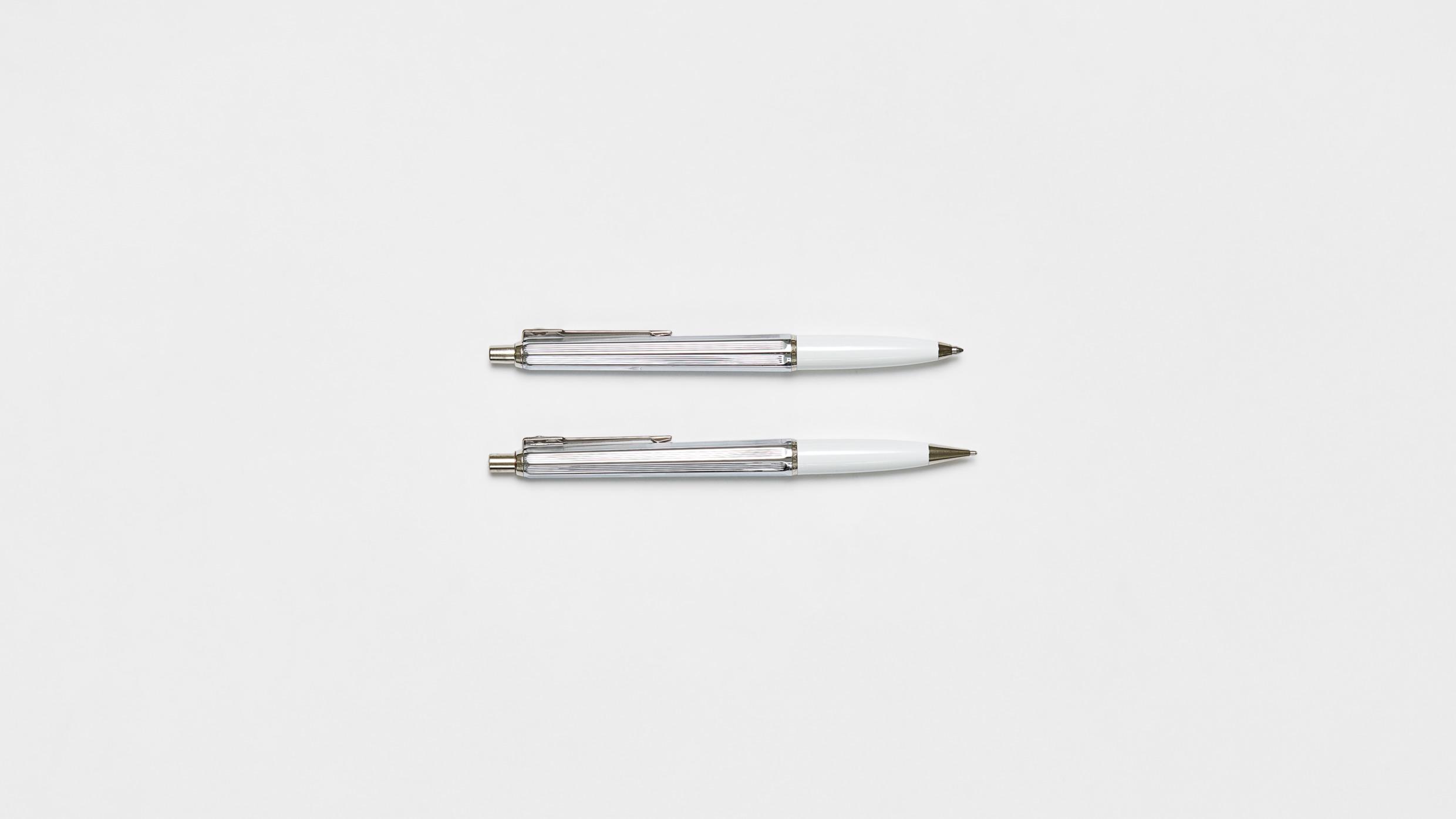 Twee ballografpennen op een wit oppervlak.