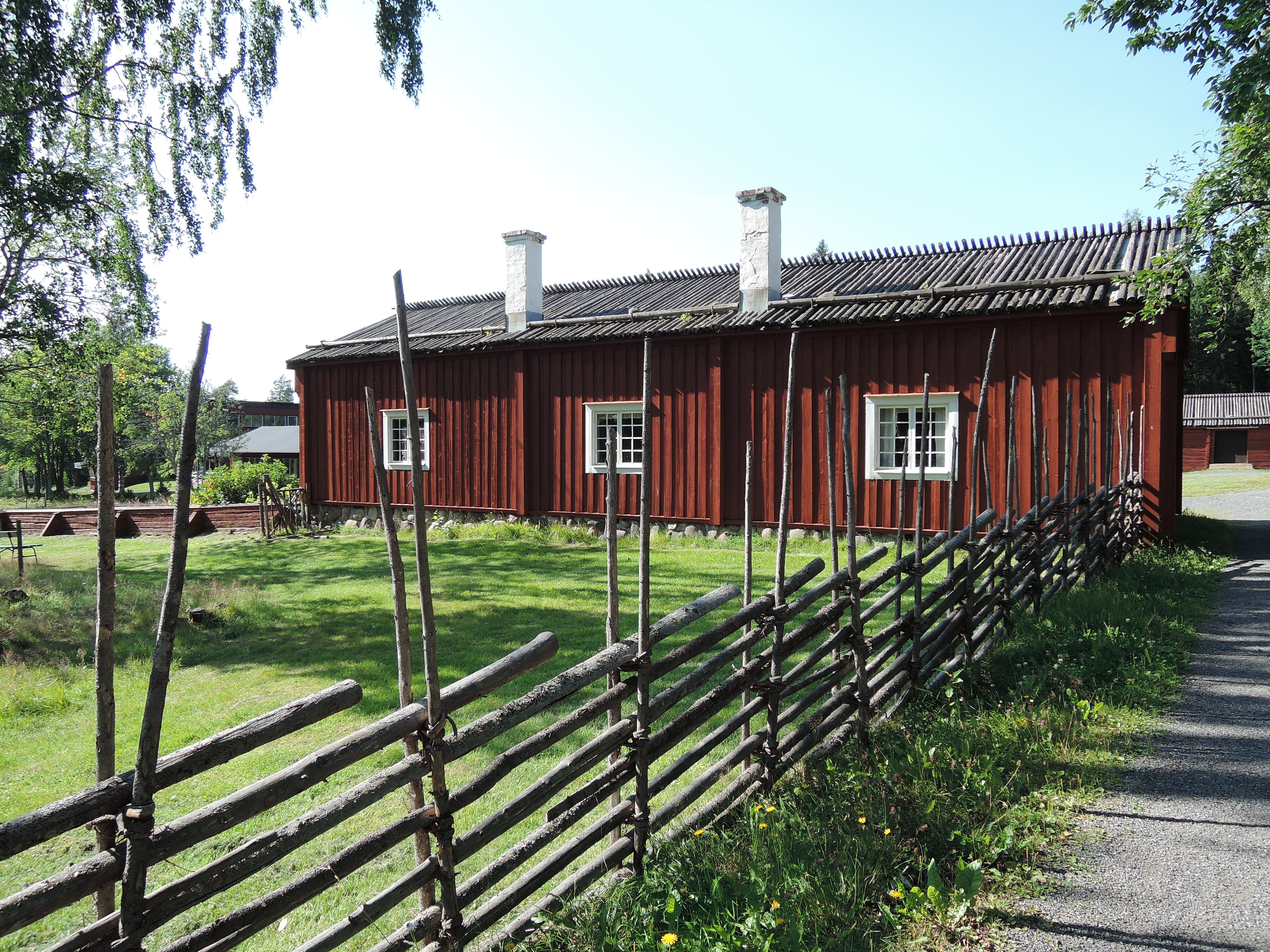 A traditional red wooden farmhouse at Gammlia Open-Air Museum, part of Västerbottens Museum in Umeå.