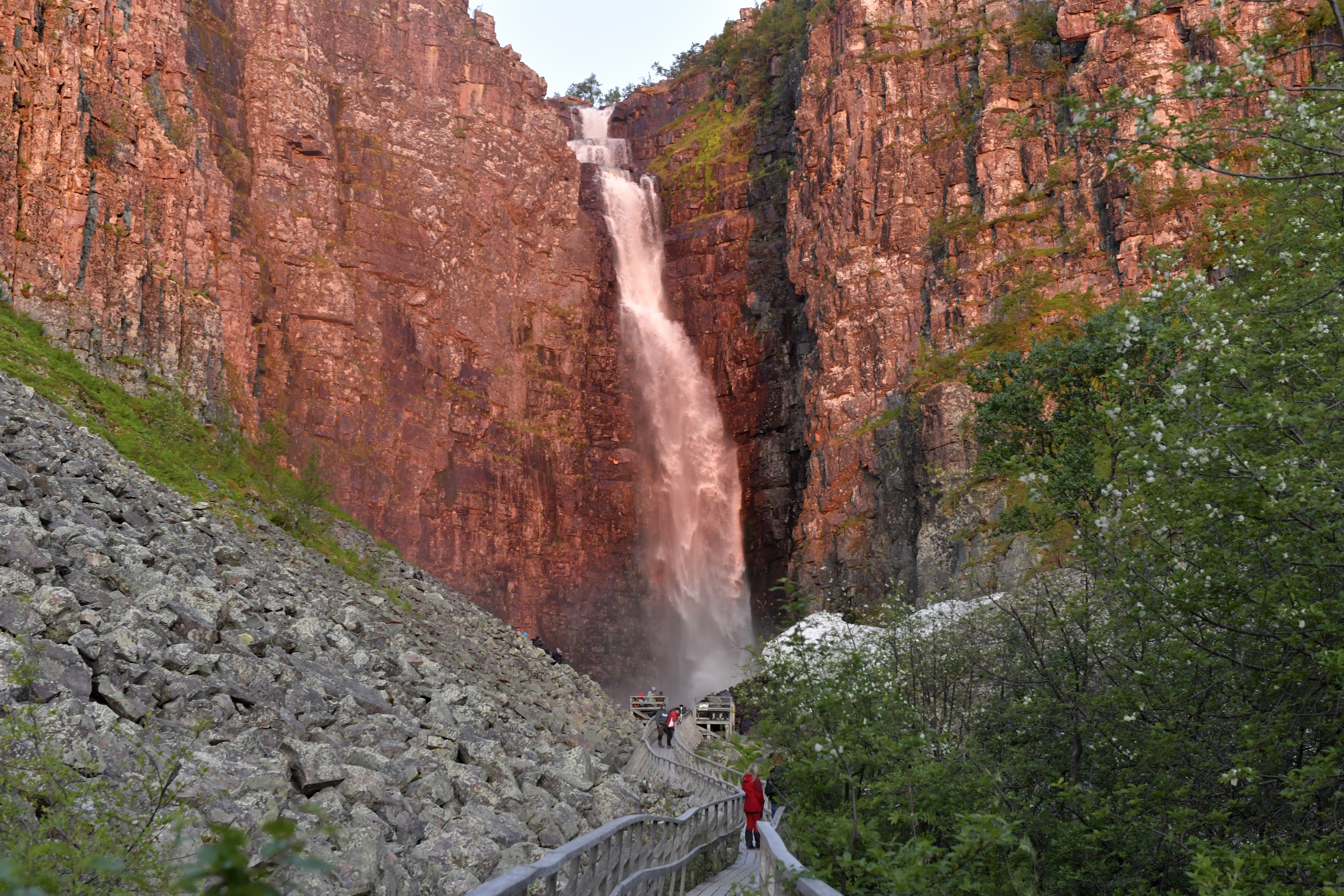 Bezoekers wandelen over het houten pad richting de Njupeskär-waterval in het Fulufjället Nationaal Park, Dalarna, Zweden.