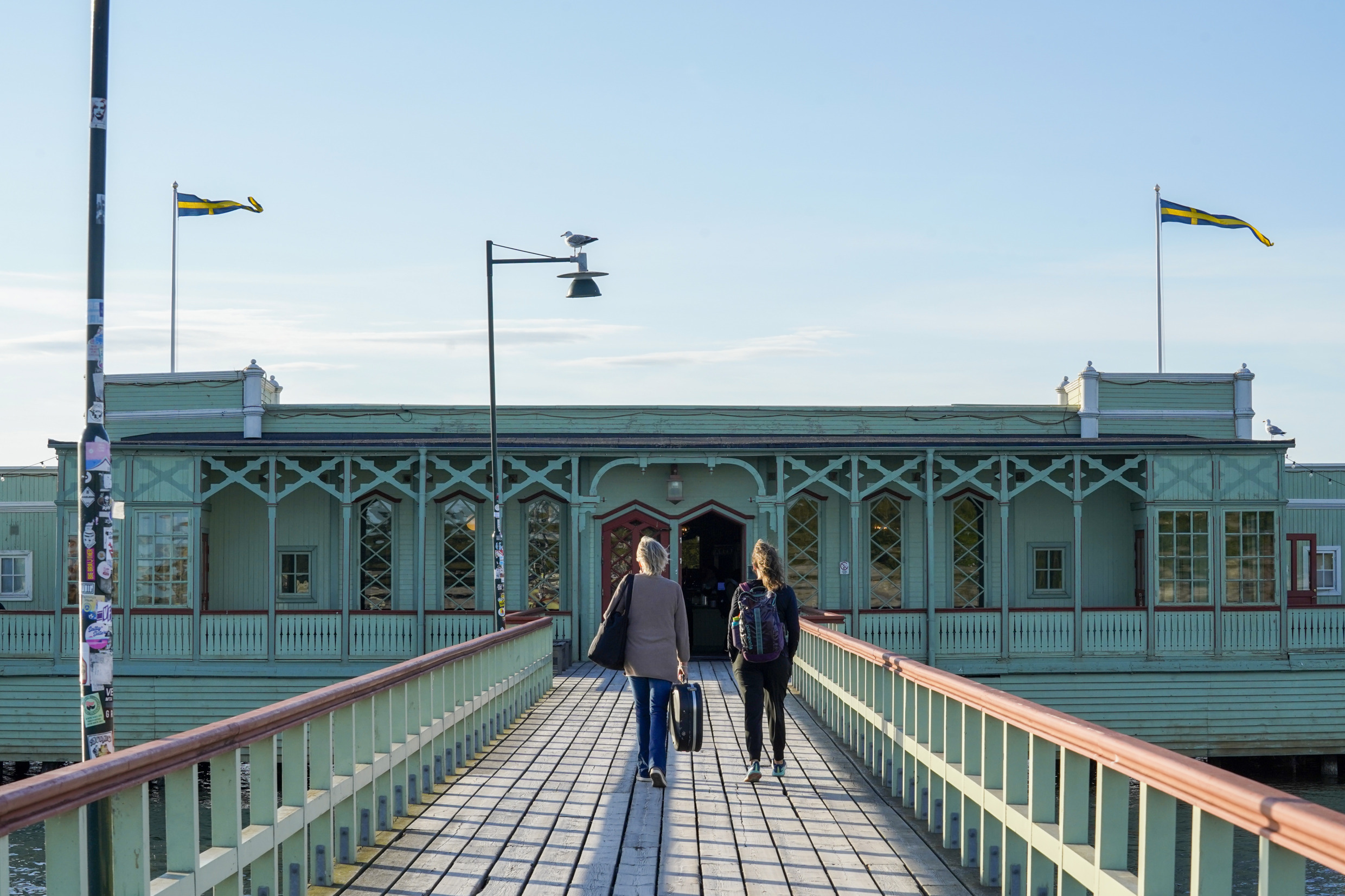 Two people walk on the wooden pier towards Ribersborg open-air baths.