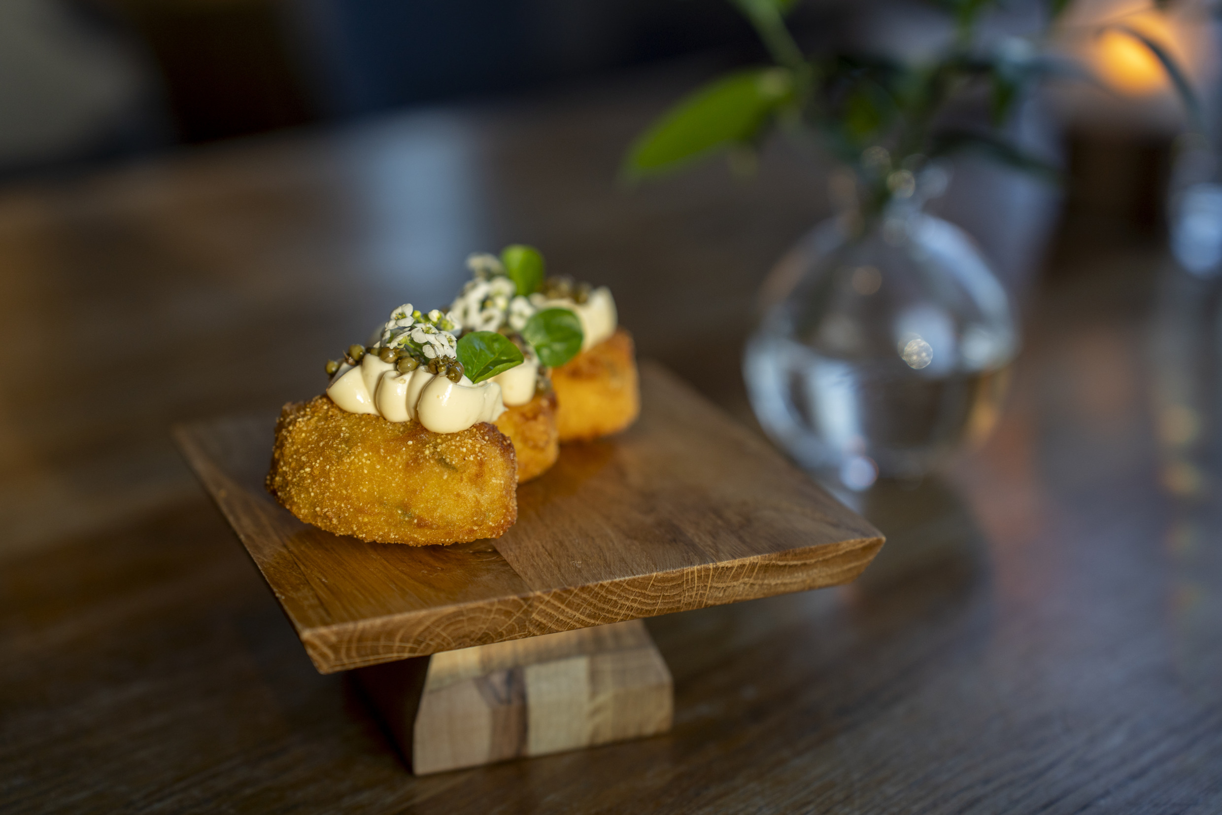 Golden-brown croquettes topped with cream and herbs, served on a plate at a Swedish hotel restaurant.