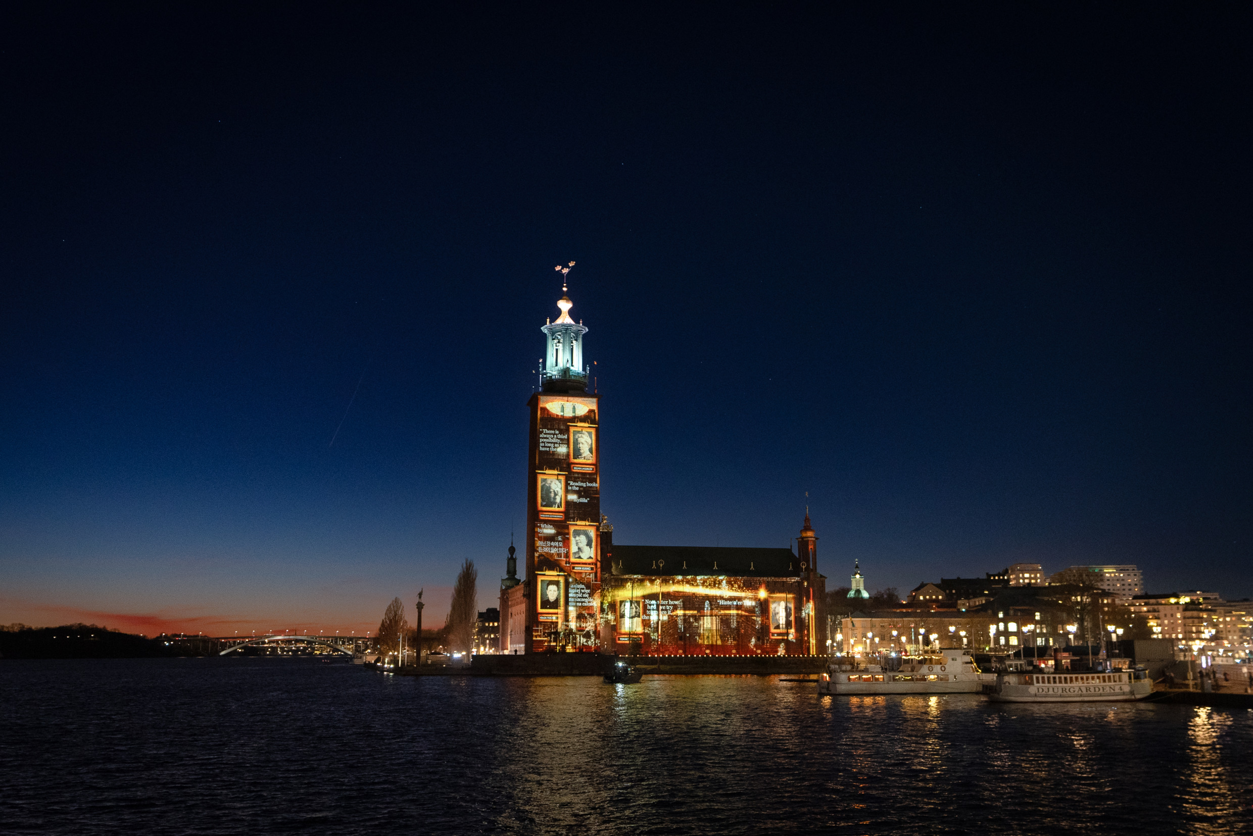 Light and images projected onto a large building in the dark.