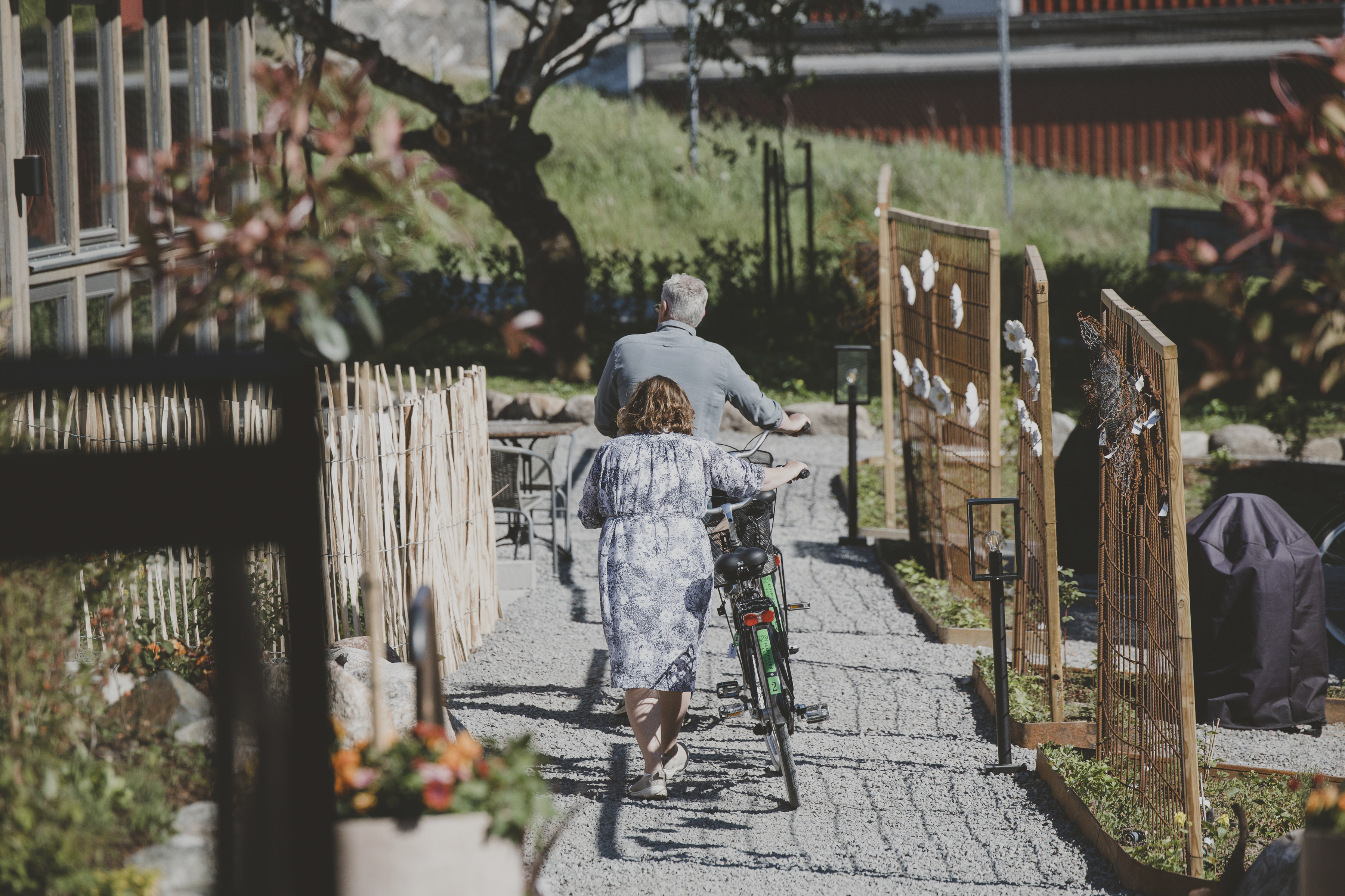 Two people walking next to their bikes.