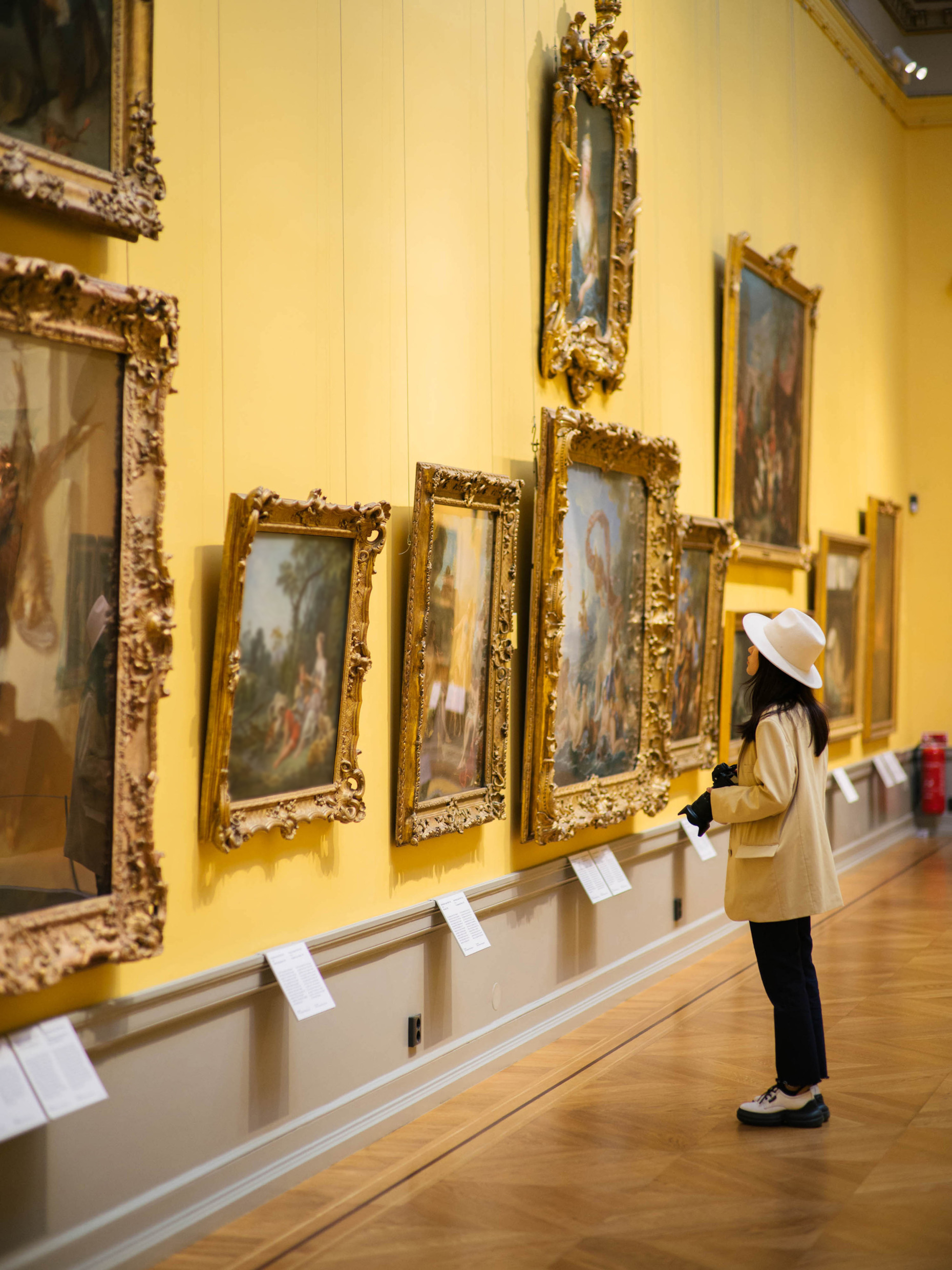 A woman looks at works of art in a museum.
