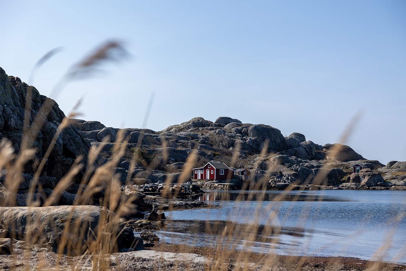 Rocky coastal landscape on Hönö in the Gothenburg archipelago, with red boathouses by the water.