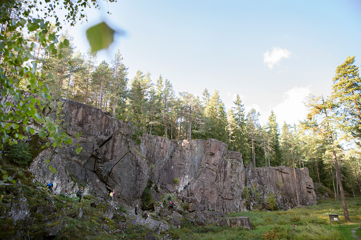 Menschen, die im Sommer neben einer Bergwand wandern.