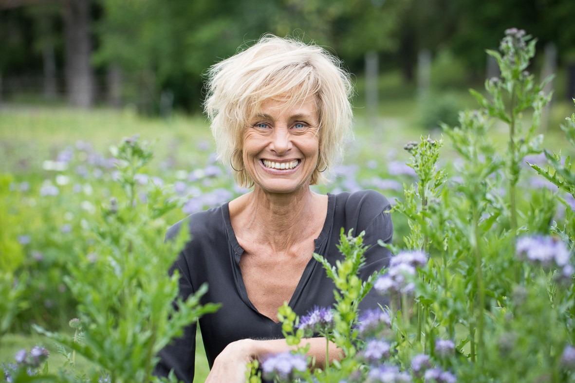 Lisen Sundgren umgeben von Blumen auf einem Feld.