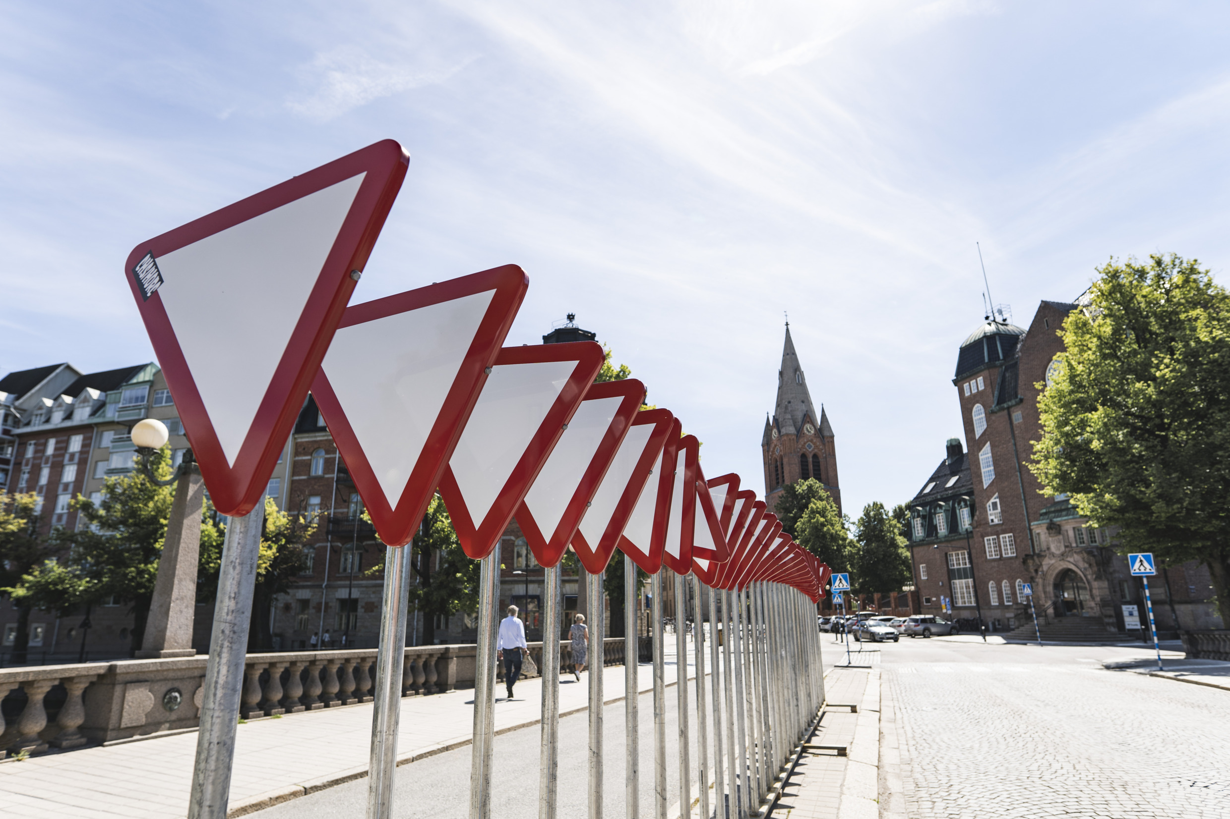 Es handelt sich um  Kunstwerke, die aus dreieckigen Verkehrsschildern besteht, die in verschiedene Richtungen gedreht und in einer Reihe angeordnet sind.